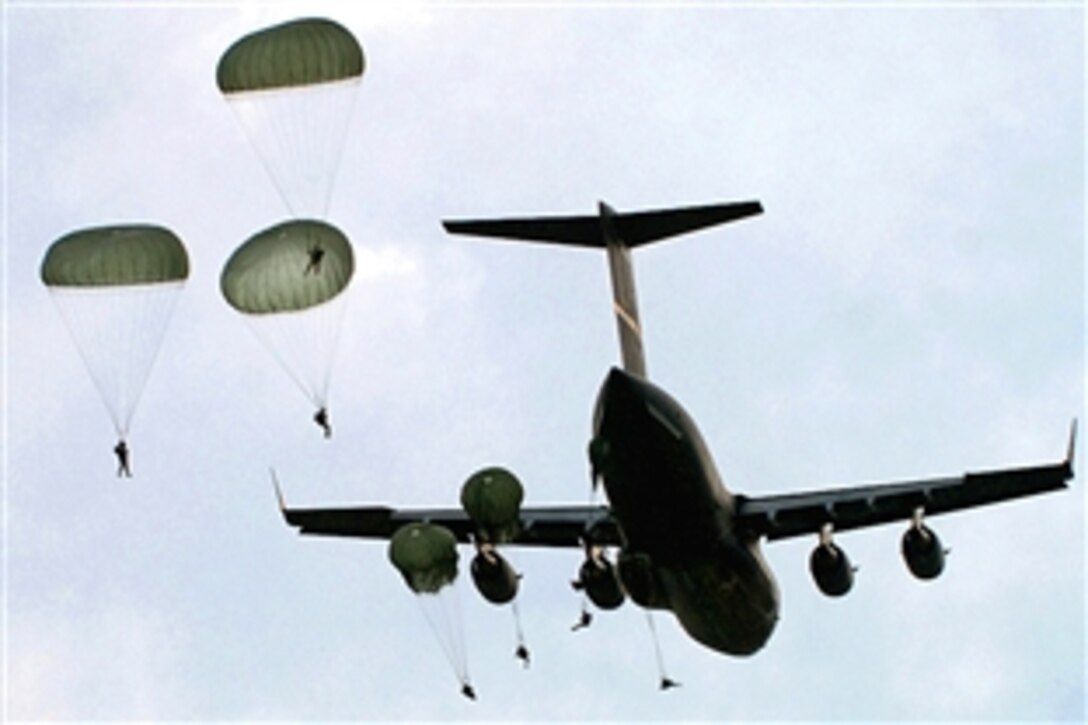 Members of the 82nd Airborne Division, Fort Bragg, NC, hook up their static  lines to the anchor cable on a US Air Force C-130 Hercules prior to their  parachute jump. The paratroopers