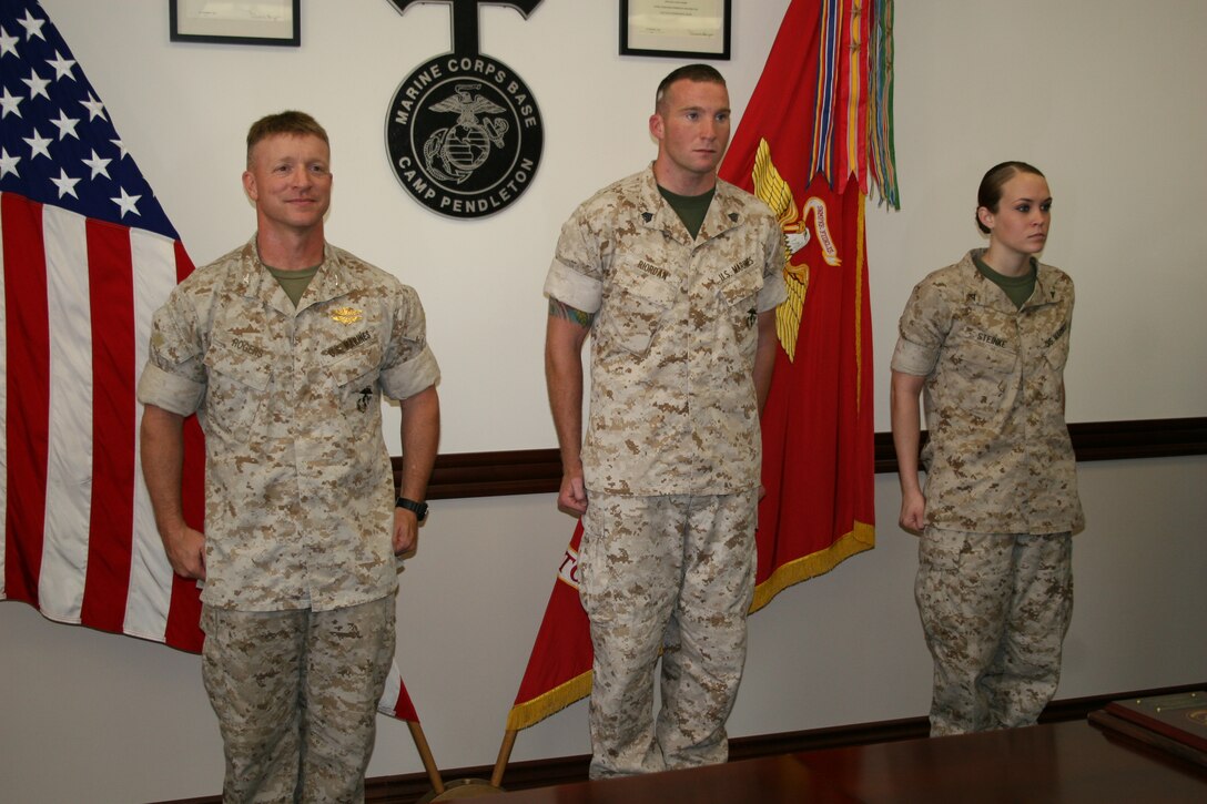 (from left to right) Col. Phillipe D. Rogers, battalion commander, Headquarters and Support Battalion, Sgt Chris P. Riordan, instructor, Training and Instruction Company, Amphibious Assualt School Battalion, and Lance Cpl. Ashley J. Stienke, seperations clerk, Installation Personnel Administration Center outbound, Headquarters and Support Battalion, stand at attention as meritorious masts are read for Riordan and Stienke after they won Noncommisioned Officer and Marine of the Quarter respectivley.