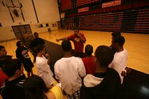 Lance Cpl. Bryant Tune, 23, a boxer on the Marine Corps Boxing Team, teaches students from Proviso West High School how to throw a punch. Tune, from Nathalie, Va., walked the kids through different offensive maneuvers during an event for Marine Week Chicago. Marines from various units came to Chicago to help the community and display the opportunities the Marine Corps can offer.