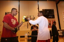 Dreylon Jones, a 19-year-old student at Proviso West High School, throws a punch at boxing mitts held by Lance Cpl. Bryant Tune. Tune, a 23-year-old boxer on the Marine Corps Boxing Team, and two other members on the team visited the high school as part of Marine Week Chicago. The Marines ran the kids through different boxing exercises. They showed them different defensive and offensive techniques.