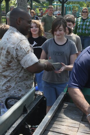 Maj. C.W. Hampton, G-3 Action Officer, Marine Forces Command, hands bricks to children willing to lend a hand to Marines of 1st Marine Division at Riis Park in Chicago May 12, 2009. Marines are cleaning up parks as well as taking part in other community services and efforts as part of Marine Week Chicago. (U.S. Marine Corps photo by Cpl. Seth Maggard/Released)