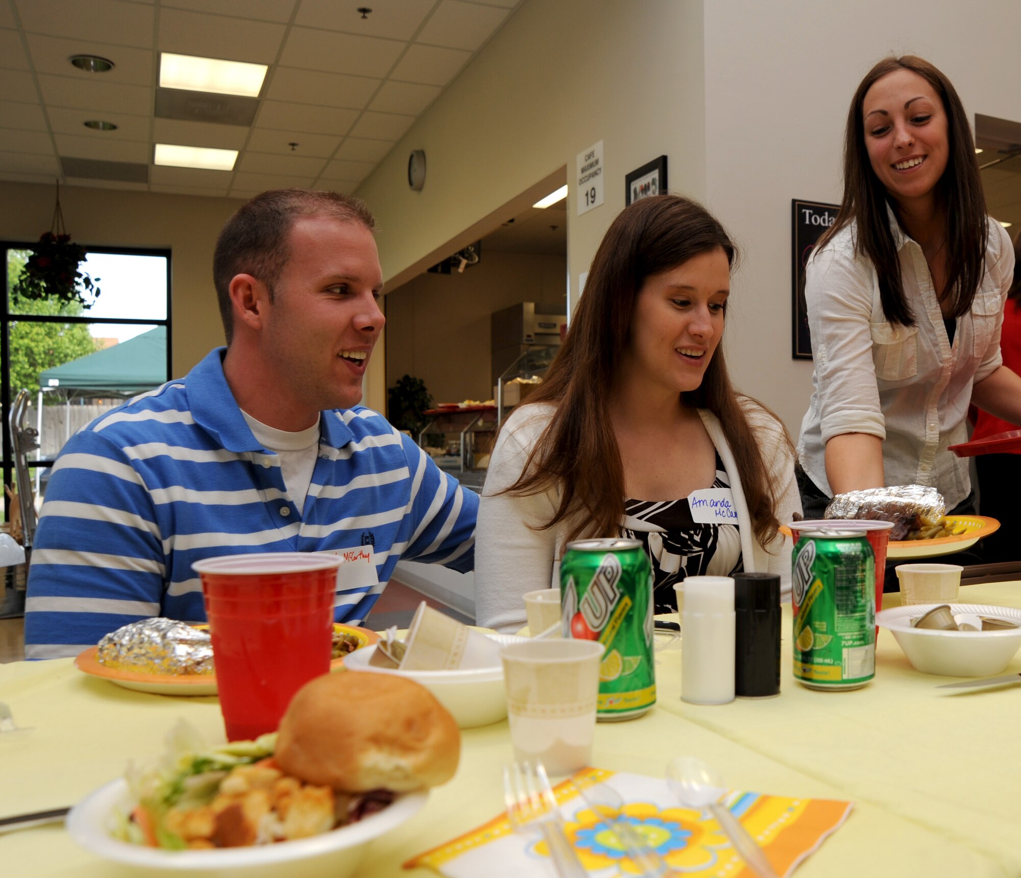 MCCONNELL AIR FORCE BASE, Kan. -- Airman 1st Class Tina Girdano, 22nd Medical Support Squadron, serves dinner to Amanda McCarthy, while husband Airman 1st Class Matt McCarthy, 22nd Aerospace Medicine Squadron waits during a spouse appreciation dinner at the School Age Program, May 11. The spouse appreciation dinner has been held once a year for the last ten years to say “thank you” for the continuous support Team McConnell spouses give. (Photo by Senior Airman Roy Lynch) 