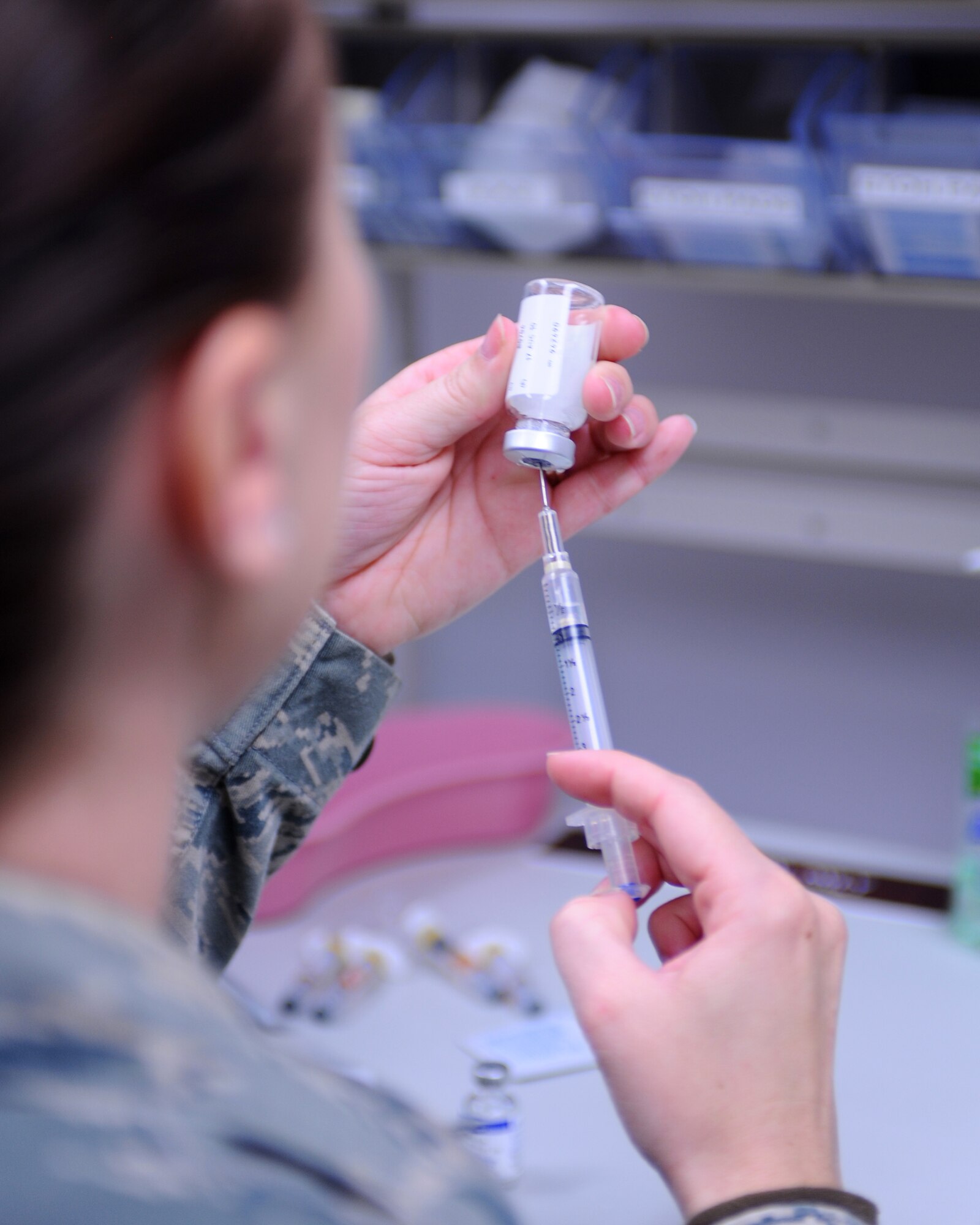 Senior Airman Megan Knutson, 28th Medical Operations Squadron medical technician, fills a syringe with a vaccination here, May 13. The immunizations clinic provides vaccinations for more than 1,500 beneficiaries in the Black Hills area. (U.S. Air Force photo/Senior Airman Kasey Zickmund)
