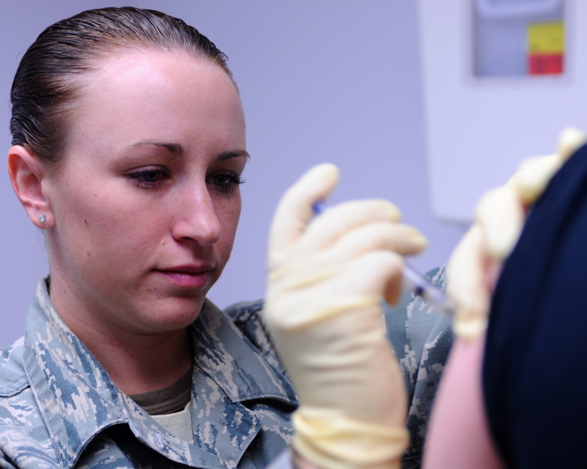 Senior Airman Megan Knutson, 28th Medical Operations Squadron medical technician, administers a vaccination to Tech. Sgt. Jesse Maddox, 28th Maintenance Squadron metals technologist, here, May 13. Sergeant Maddox received the vaccination in preparation for a deployment. (U.S. Air Force photo/Senior Airman Kasey Zickmund)