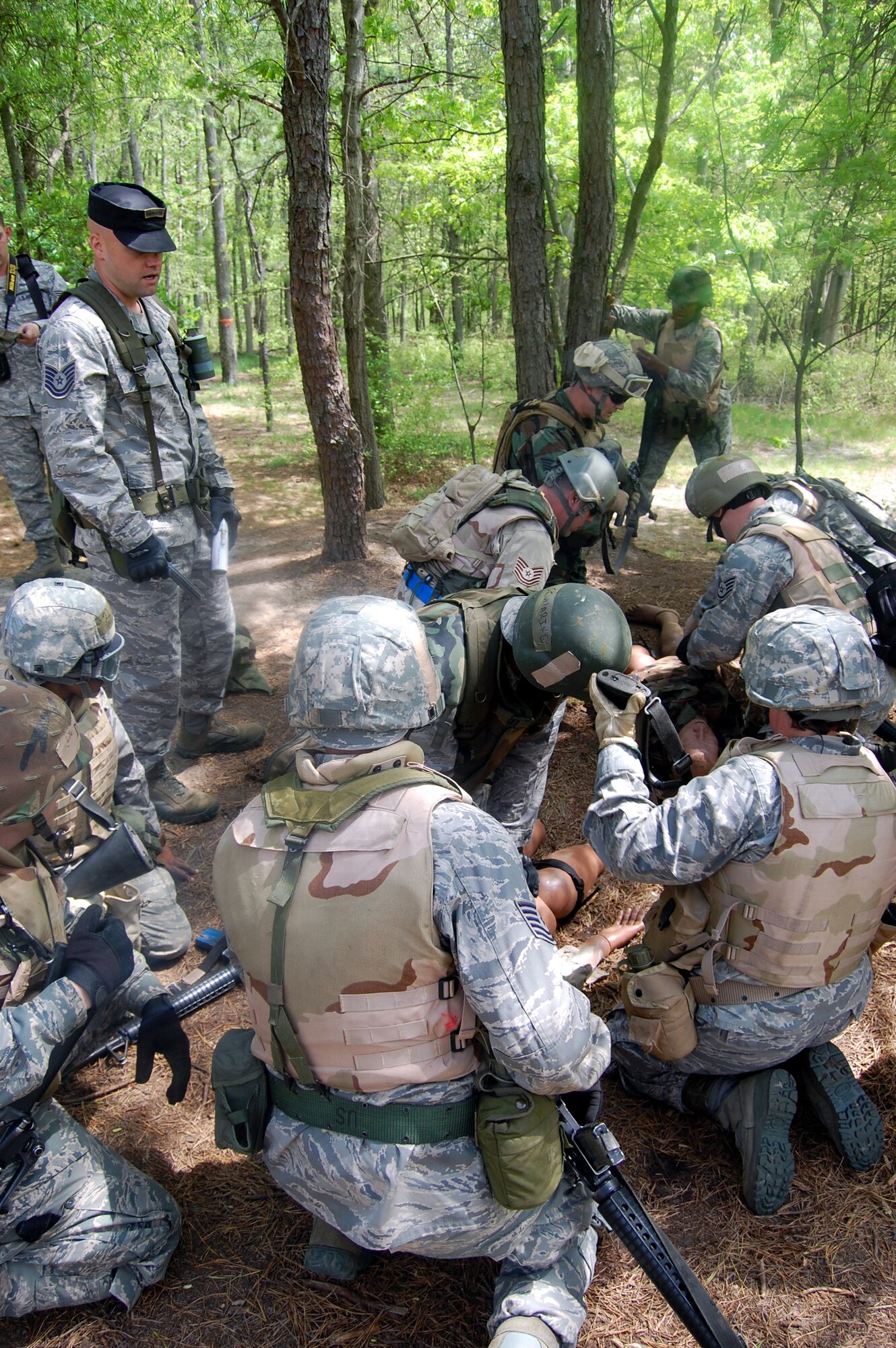 Tech. Sgt. Matt Thompson, contingency skills instructor, watches as students in the Advanced Contingency Skills Training Course respond to a combat first aid scenario during training on a Fort Dix, N.J., range on May 11, 2009.  The training, taught by the U.S. Air Force Expeditionary Center's 421st Combat Training Squadron on Fort Dix, prepares Airmen for upcoming deployments.  (U.S. Air Force Photo/Tech. Sgt. Scott T. Sturkol)