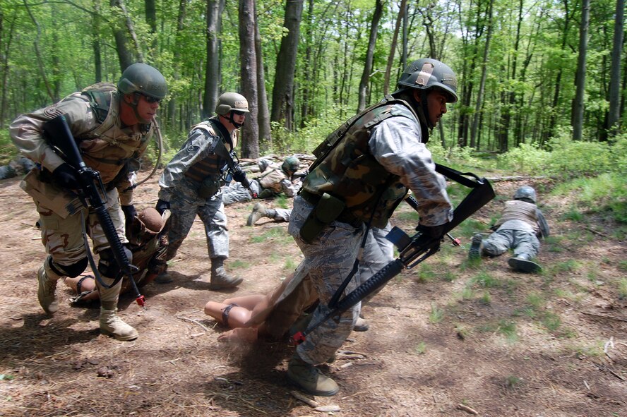 Students in the Advanced Contingency Skills Training Course move simulated victims during training on a Joint Base McGuire-Dix-Lakehurst, N.J., range on May 11, 2009. The training, taught by the U.S. Air Force Expeditionary Center's 421st Combat Training Squadron on Fort Dix, prepares Airmen for upcoming deployments. One Air Mobility Command Airman from Little Rock Air Force Base, Ark., credited the training for saving her life after an improvised explosive device attack in Iraq in August 2009. (U.S. Air Force Photo/Tech. Sgt. Scott T. Sturkol) 