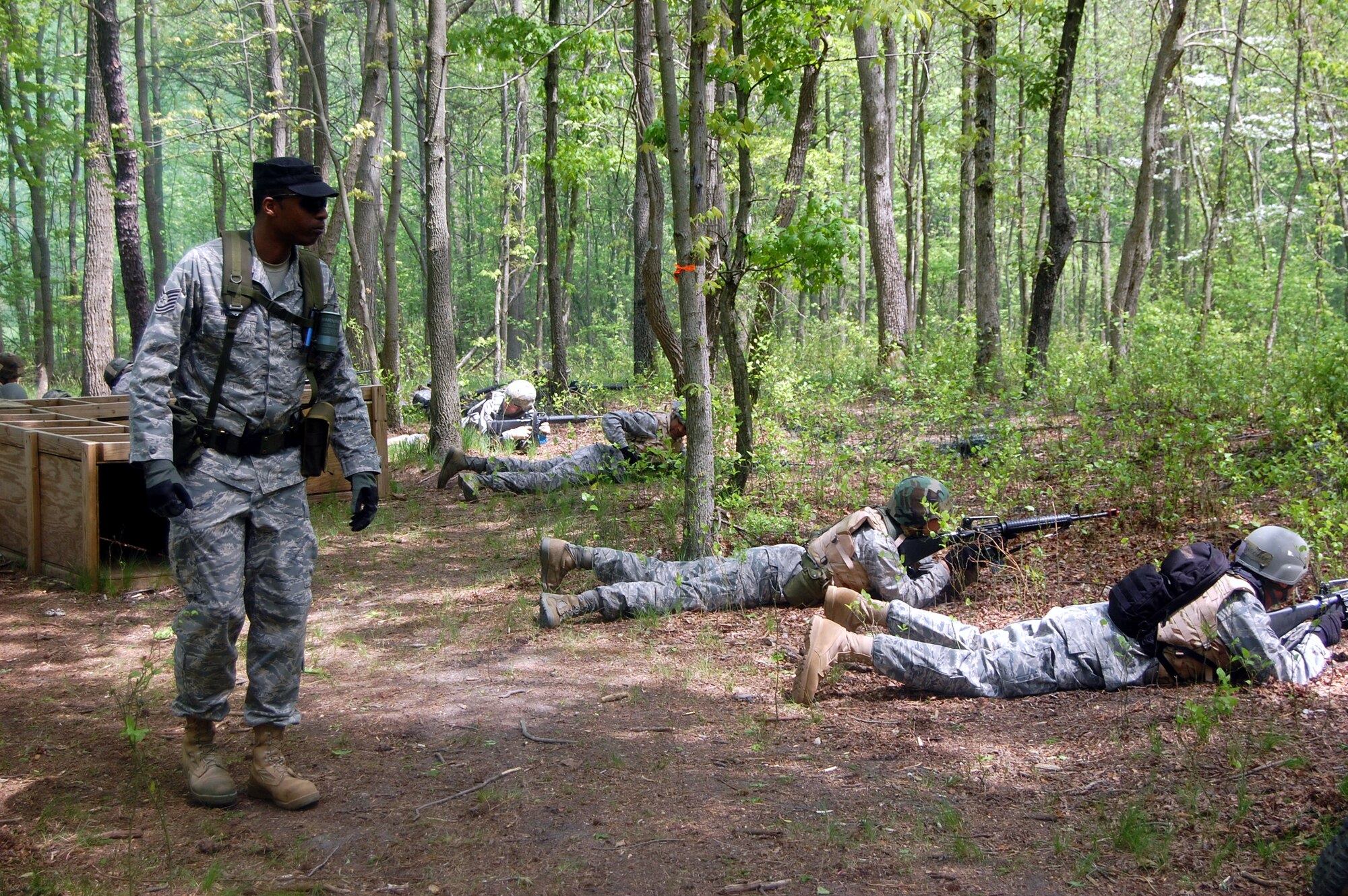Tech. Sgt. Bernard Wilson, contingency skills instructor, watches as students in the Advanced Contingency Skills Training Course respond to a scenario requiring response to "enemy fire" during training on a Fort Dix, N.J., range on May 11, 2009.  The training, taught by the U.S. Air Force Expeditionary Center's 421st Combat Training Squadron on Fort Dix, prepares Airmen for upcoming deployments.  (U.S. Air Force Photo/Tech. Sgt. Scott T. Sturkol)
