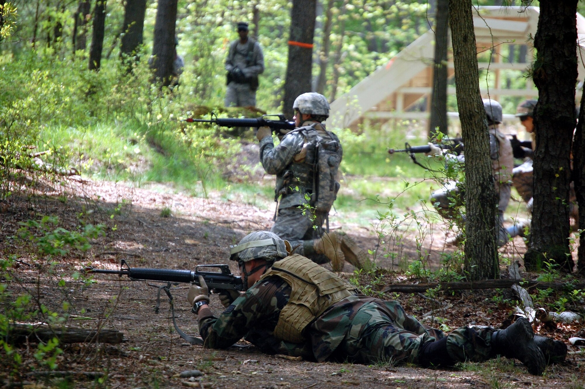 Students in the Advanced Contingency Skills Training Course react to a scenario involving "enemy fire" during training on a Fort Dix, N.J., range on May 11, 2009.  The training, taught by the U.S. Air Force Expeditionary Center's 421st Combat Training Squadron on Fort Dix, prepares Airmen for upcoming deployments.  (U.S. Air Force Photo/Tech. Sgt. Scott T. Sturkol)