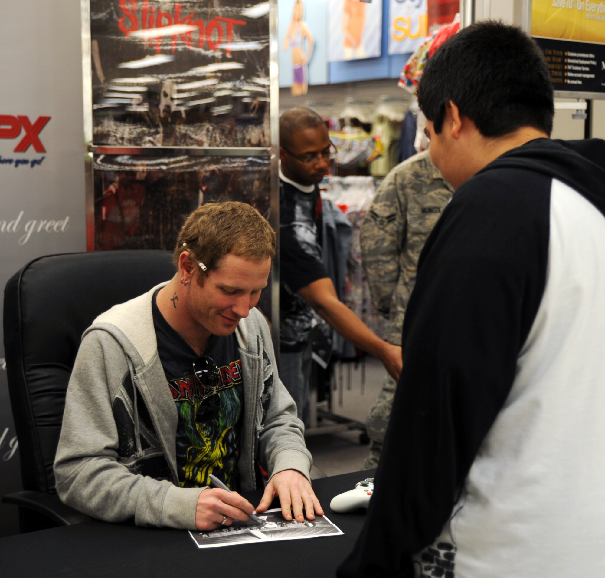 MCCONNELL AIR FORCE BASE, Kan. -- Hector Ruiz, 16, brother of Airman 1st Class Maria Ruiz, 22nd Director of Staff admin, gets an autograph from heavy metal band Slipknot’s lead singer, Corey Taylor, during a signing at the Base Exchange, May 10.  Slipknot made an appearance at the base before performing in the Wichita area. (Photo by Senior Airman Laura Suttles)