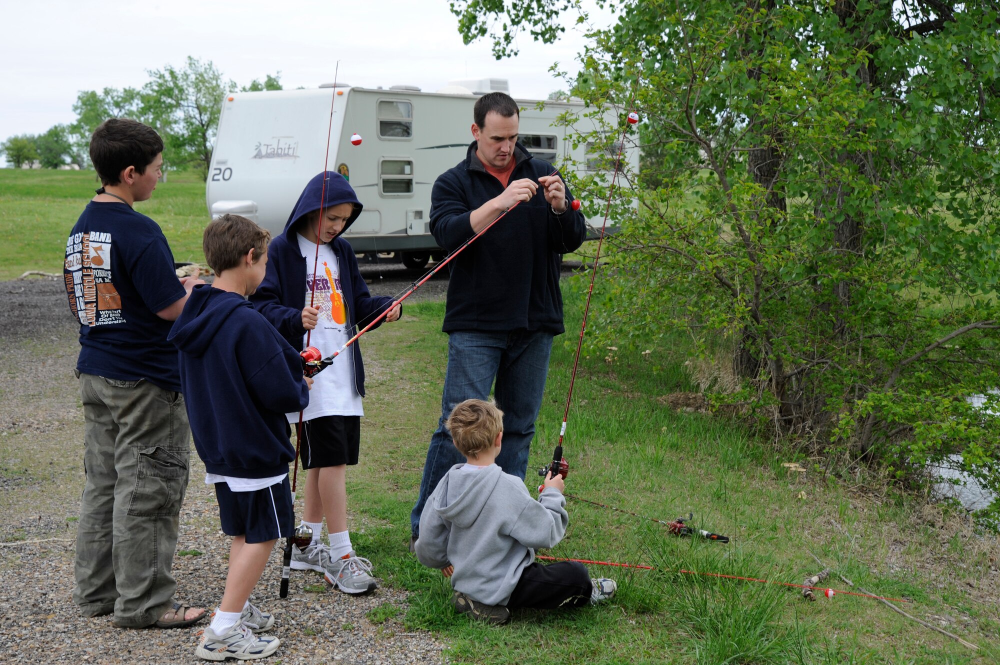 MCCONNELL AIR FORCE BASE, Kan. -- Capt. Aaron Harris, 22nd Medical Operations Squadron, assists Justin Clark, 13, Joseph Harris, 9, Nathaniel Harris, 11, and James Harris, 7, with their fishing gear at the Krueger Recreation Area, May 9. The Krueger Recreation Area opened April 4, in remembrance of deceased vice wing commander, Col. Michael V. Krueger. (Photo by Airman 1st Class Justin Shelton)