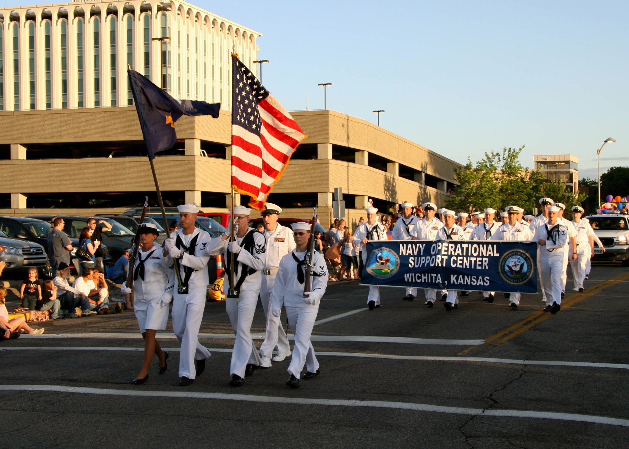 WICHITA, Kan. -- A Navy honor guard leads officers and enlisted members of Naval Operational Support Center Wichita, in the Sundown Parade as the official kickoff to the nine-day Wichita River Festival gets underway. An estimated 40,000 people watched along the parade route as various walking units, marching bands and floats entertained the audience throughout the evening. (Photo by Mass Communication Specialist 2nd Class Ron Trevino)
