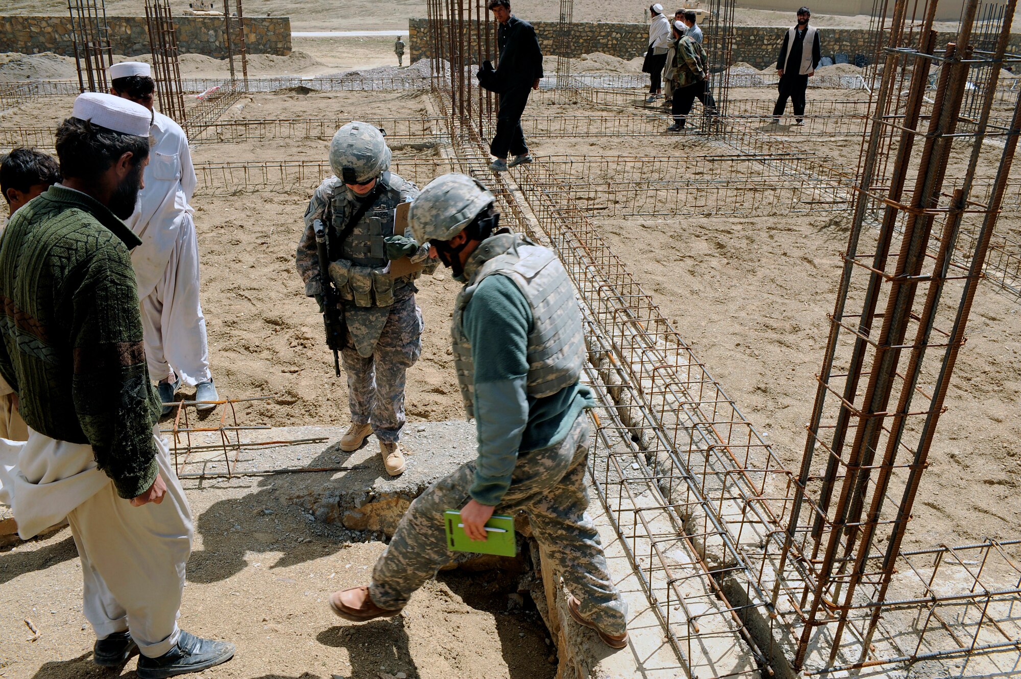 Maj. Kimberly Riggs talks with her interpreter and local contractors about construction work for the Osman Khel School April 13 in Gardez City, Afghanistan. Major Riggs is the engineer officer in charge of the Paktya Provincial Reconstruction Team. (U.S. Air Force photo/Staff Sgt. Shawn Weismiller) 
