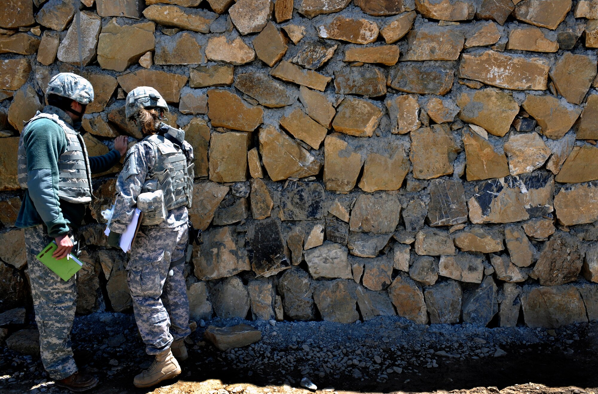 Maj. Kimberly Riggs works with her interpreter to assess masonry work at the Sayed Karam Female Medical Providers Quarters April 13 in Gardez City, Afghanistan. Major Riggs is the engineer officer in charge of the Paktya Provincial Reconstruction Team. (U.S. Air Force photo/Staff Sgt. Shawn Weismiller) 
