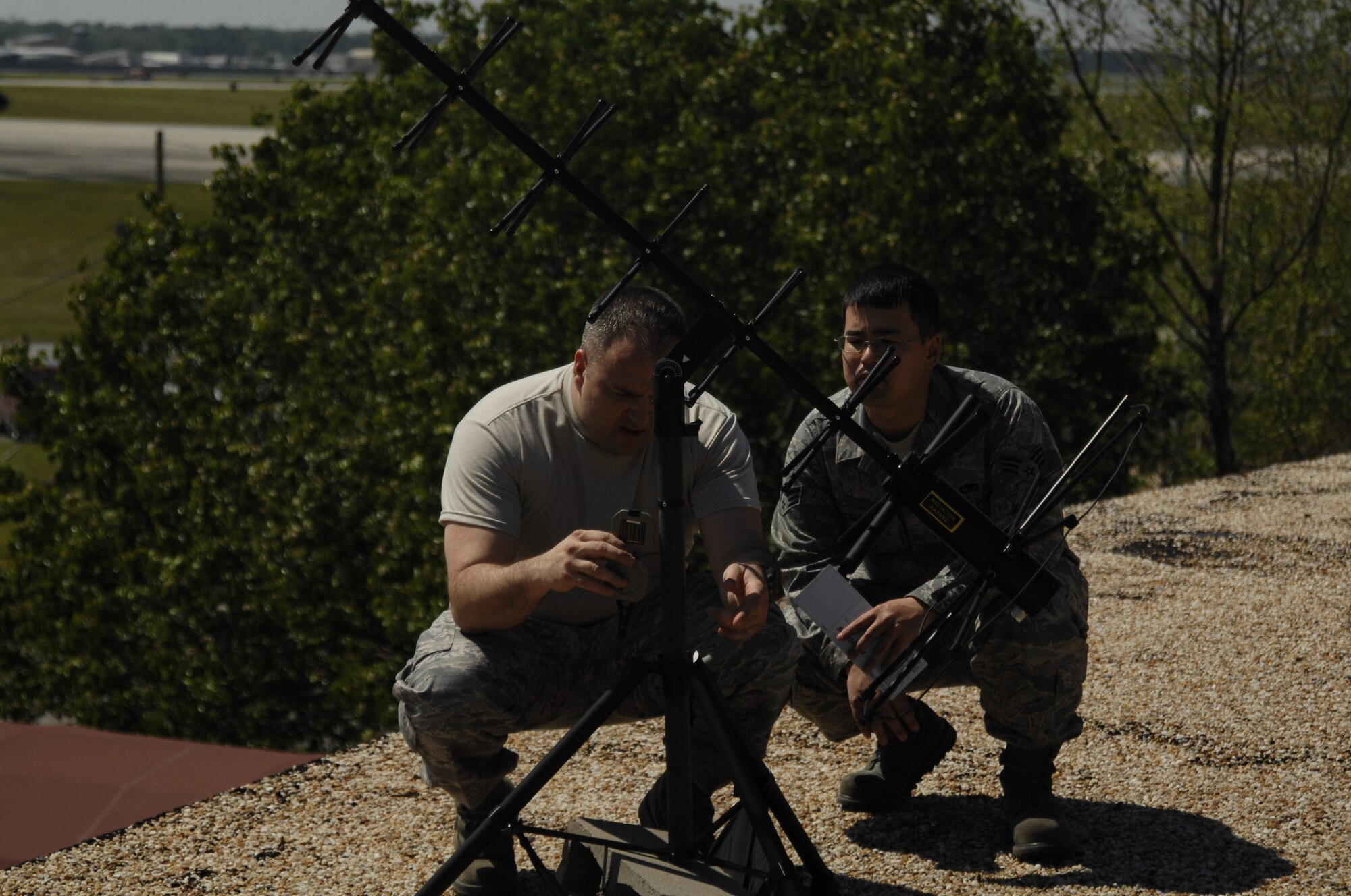 MCCONNELL AIR FORCE BASE, Kan. -- Tech. Sgt. John Jennings and Senior Airman Kyle Mitsuyasu, 22nd Operations Group, set up high gain ultra high frequency antennas at an undisclosed location, April 15. With these antennas, McConnell Airmen can communicate with aircraft in the air from the ground and provide real time data.  (Photo by Staff Sgt. Ronald Lafosse)