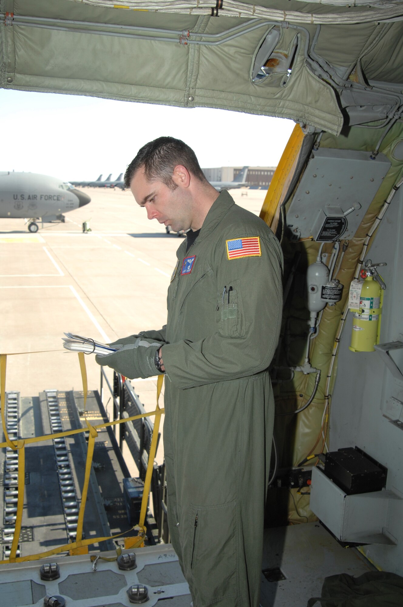 MCCONNELL AIR FORCE BASE, Kan. -- Staff Sgt. Gary Shamlian, 349th Air Refueling Squadron boom operator, double checks his checklists after cargo has been loaded, April 15. Four turbofans, mounted under 35-degree swept wings, power the KC-135 to takeoffs at gross weights up to 322,500 pounds. Nearly all internal fuel can be pumped through the flying boom, the KC-135 Stratotanker’s primary fuel transfer method.   (Photo by Staff Sgt. Ronald Lafosse)