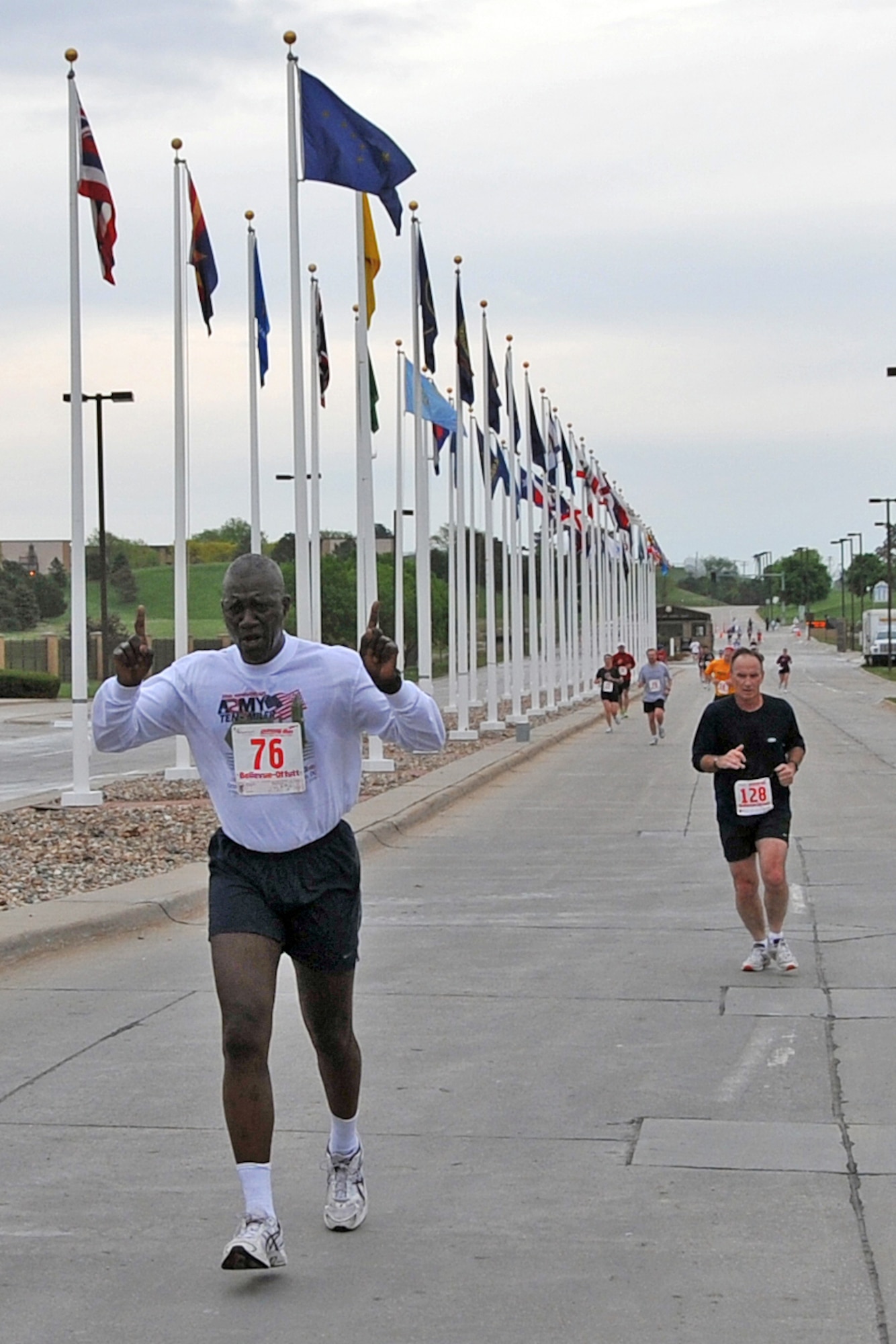 OFFUTT AIR FORCE BASE, Neb. - Maj Gen Abraham Turner, U.S. Strategic Command chief of staff,  puts his fingers up as he runs out the Kenney Gate during the final stretch of the 2nd annual Runway Run here May 10. Gen Turner finished the seven mile race in 58 minutes and 17 seconds, outrunning 106 of 161 runners. U.S. Air Force Photo by Jeff W. Gates