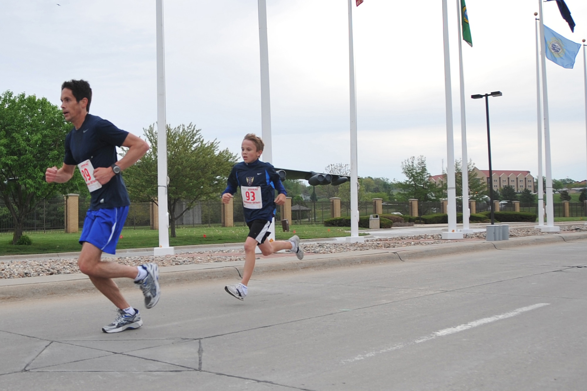 OFFUTT AIR FORCE BASE, Neb. - Timothy Langdon and  Justin Liedke run out the Kenney Gate during the final stretch of the Runway Run here May 10. Mr. Liedke finished the seven mile run in first place overall with a time of  41 minutes and 49 seconds. Mr. Langdon finished in first place of the male 19-29-category with a time of 41 minutes and 52 seconds. Air Force Photo by Jeff W. Gates
