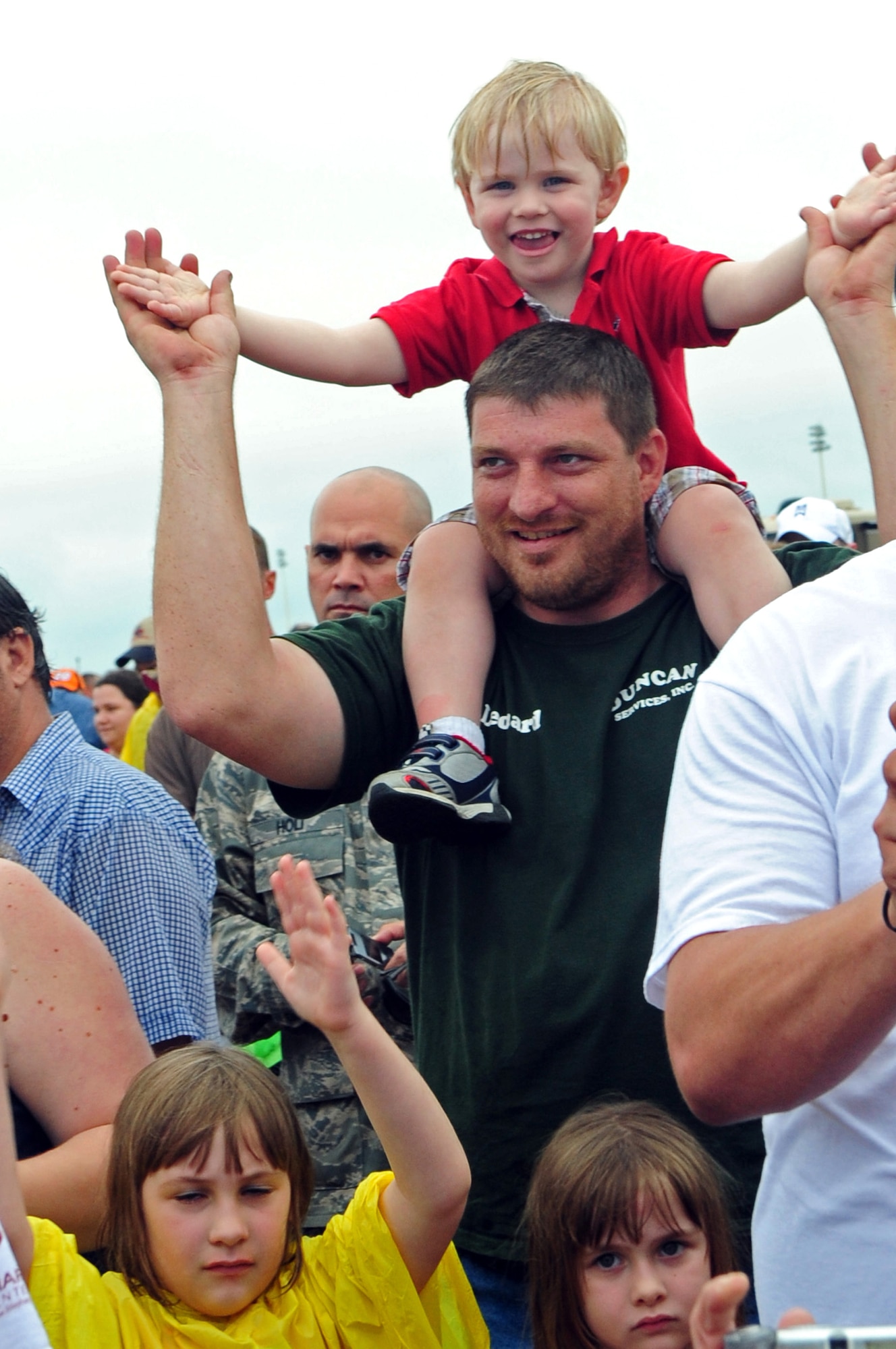 BARKSDALE AIR FORCE BASE, La., -- Leonard Jones of Bossier City and his son Logan, 3, clap along with country music recording artist Aaaron Tippen during a performance on the final day of the Defenders of Liberty Air Show, May 10. More than 1,000 air show spectators waited through inclement weather to see Aaron perform on Mother's Day. (U.S. Air Force photo by Senior Airman Joanna M. Kresge)(Released)