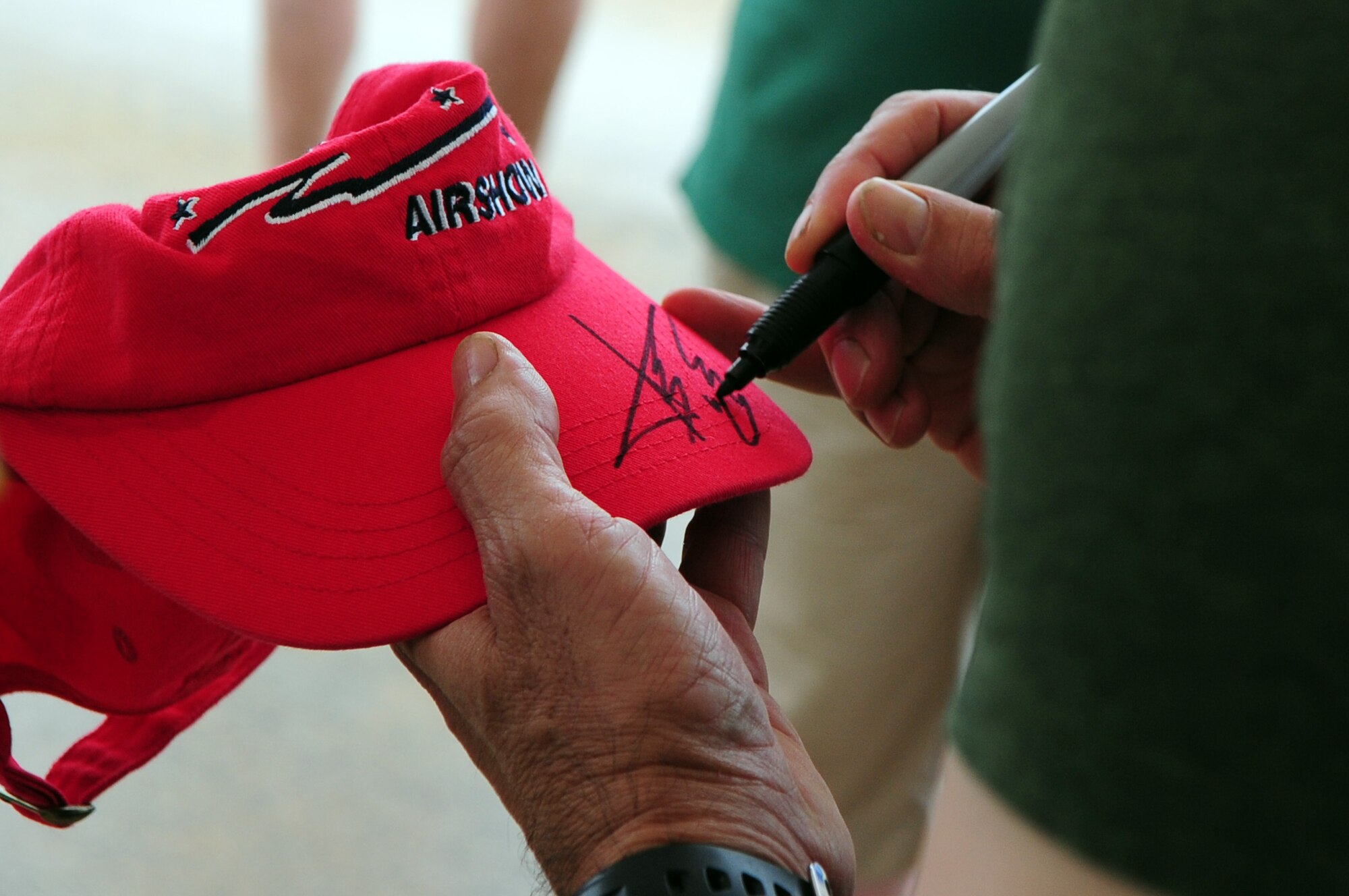 BARKSDALE AIR FORCE BASE, La. - Country music recording artist Aaaron Tippen autographs a Barksdale Air Show hat prior to his performance on the final day of the Defenders of Liberty Air Show, May 10. More than 1,000 air show spectators waited through inclement weather to see Aaron perform on Mother's Day. (U.S. Air Force photo by Senior Airman Joanna M. Kresge)(Released)