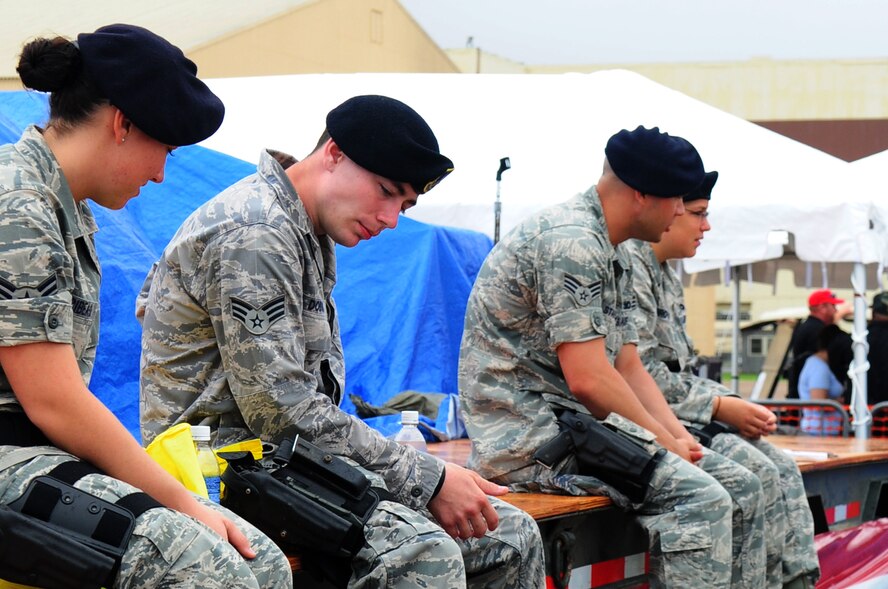 BARKSDALE AIR FORCE BASE, La., -- Members of the 2d Security Forces Squadron sit on stage prior to the start of a concert by country music recording artist Aaaron Tippen on the final day of the Defenders of Liberty Air Show, May 10. More than 1,000 air show spectators waited through inclement weather to see Aaron perform on Mother's Day. (U.S. Air Force photo by Senior Airman Joanna M. Kresge)(Released)