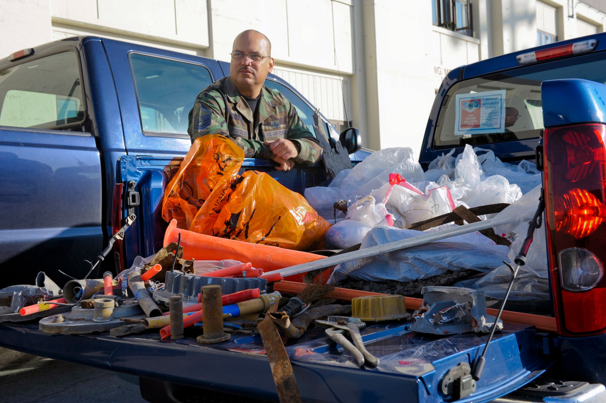 ELMENDORF AIR FORCE BASE, Alaska -- Master Sgt. Joseph Montalvo leans on a truck full of items found on the FOD walk earlier in the day. FOD walks are an annual process which requires airmen to walk and check the flighline for debris that may damage ground vehicles or aircraft.(U.S Air Force photo/Master Sgt. Keith Brown)