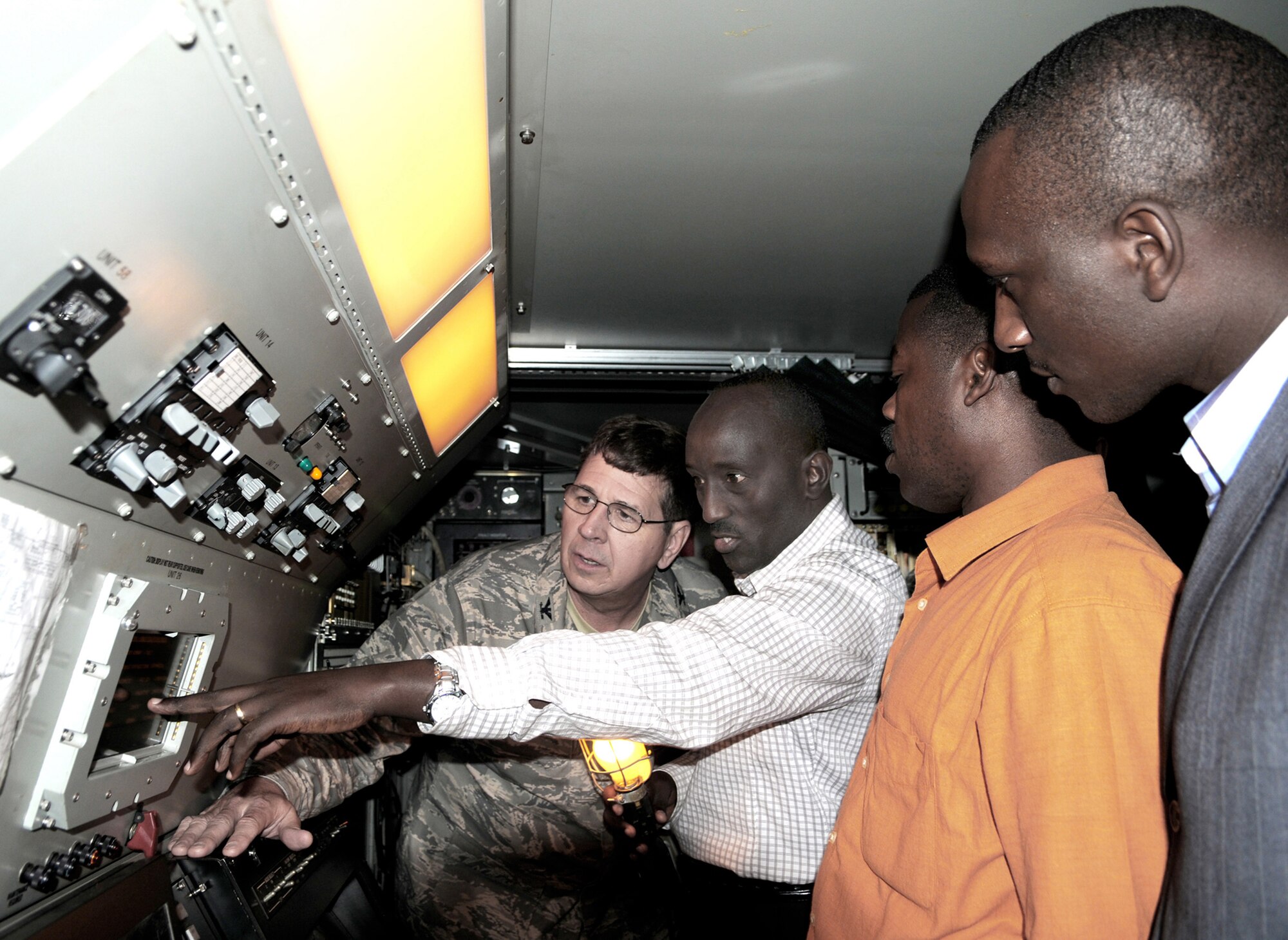 Engineer Eustache Karagire (center) explains the Aerospace Management System radar to Col. Robert McGrath from the 145th Airlift Wing at Charlotte, N.C., while 2nd Lt. Sylvester Manirambona (right from center) and Innocent Minega (right) watch at Kilgali, Rwanda. 
