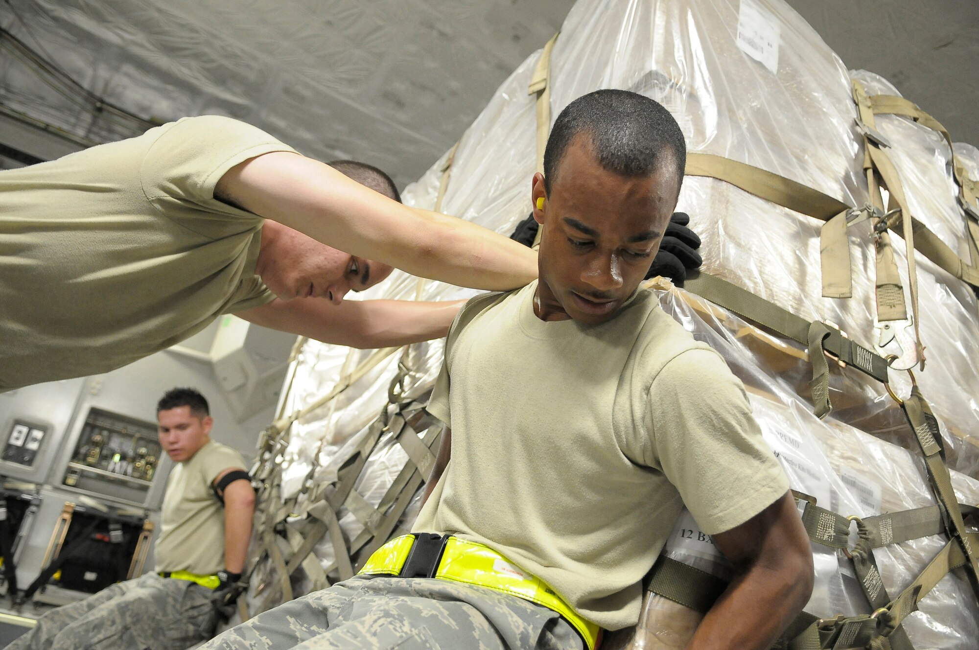 Airman 1st Class Marvin Richardson, front, Airman 1st Class Daniel Anderson, center, and Airman Rodrigo Maranon, back, push a pallet of personal protection kits onto a C-17 May 8 at Charleston Air Force Base, S.C. The personal protection kits were shipped to Haiti, El Salvador, Guatemala, Honduras and Nicaragua, where health-care officials are responding to confirmed and suspected cases of H1N1 Influenza-A infections. U.S. Southern Command, with headquarters in Miami, directed the mission after learning health officials submitted requests for assistance to U.S. embassies in their respective countries. Airmen Richardson, Anderson and Maranon are air transportation specialists with 437th Aerial Port Squadron at Charleston AFB. (U.S. Air Force photo/James M. Bowman)