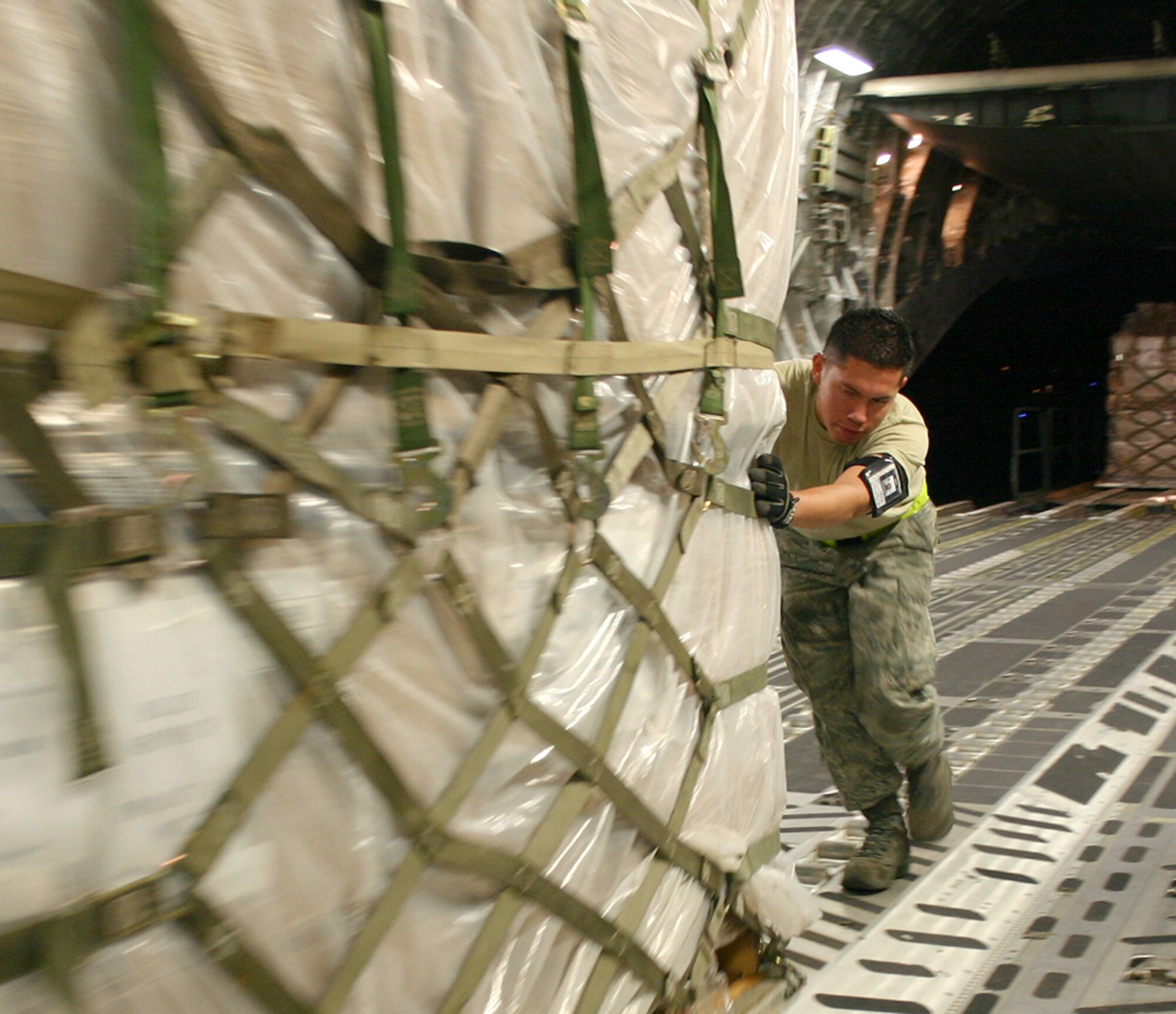 Air Cargo Specialist Senior Airman Rodrigo Maranon from the 437th Aerial Port Squadron pushes a pallet of personal protective kits into position aboard a C-17 Globemaster III at Charleston Air Force Base, S.C., May 8. The kits are part of a U.S. Agency for International Development shipment to Haiti, Guatemala, Honduras, El Salvador, Nicaragua and Belize to help these nations prepare for a potential outbreak of the H1N1 influenza virus. (U.S. Air Force photo/Raymond Sarracino)