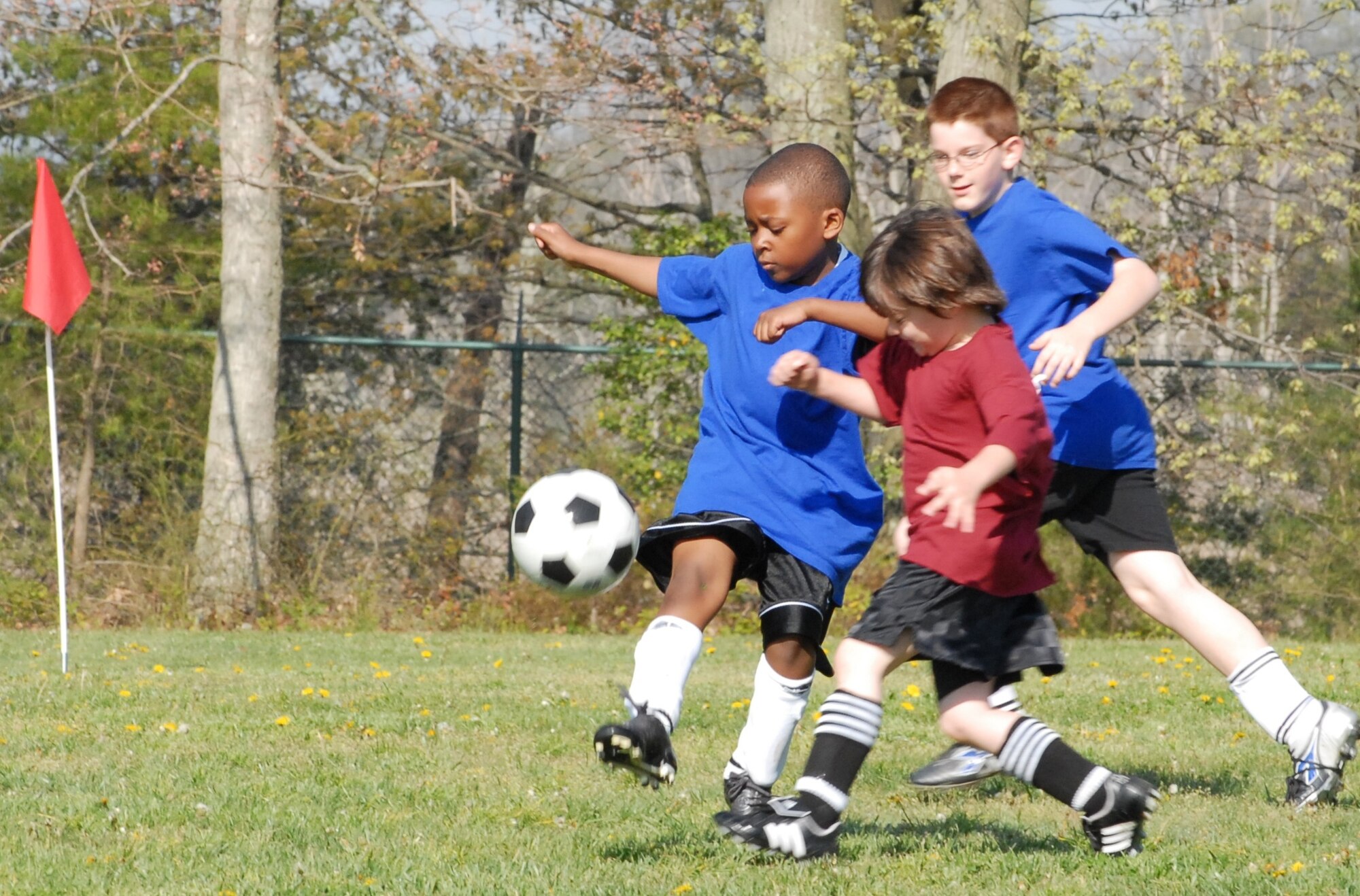 Justin Washington (left), a Blue Dragons defender, challenges Dylan Stoltzfus, a Flames offensive player, to the ball as Blue Dragons teammate Ethan Carello backs him up during a Youth Center soccer game at Dover Air Force Base May 11. The Blue Dragons were defeated 4 ? 2. This is the final week of this year?s Youth Center soccer league.  (U.S. Air Force photo by Tech. Sgt. Kevin Wallace)