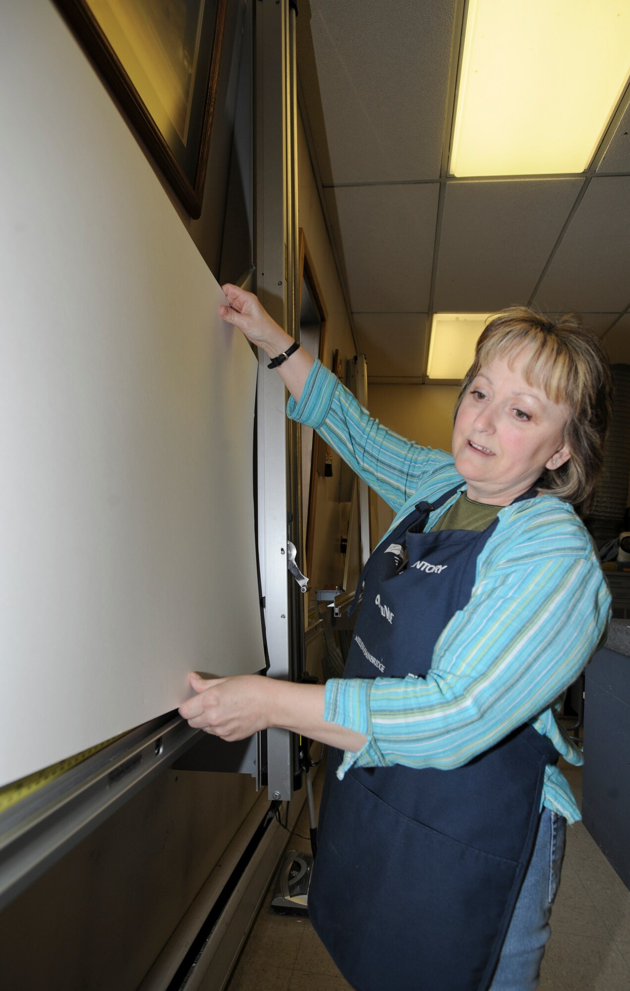 ELMENDORF AIR FORCE BASE, Alaska -- Tracey Hunnwell, 3rd Services Squadron coordinator, prepares to cut some red matting for a retirement shadow box at the Arts and Crafts Center, May 5, 2009. The center provides services to military members and their families varying from shadow boxes, plaques, pottery, glass blowing and many more styles of art.(U.S. Air Force photo/Senior Airman Matthew Owens)
