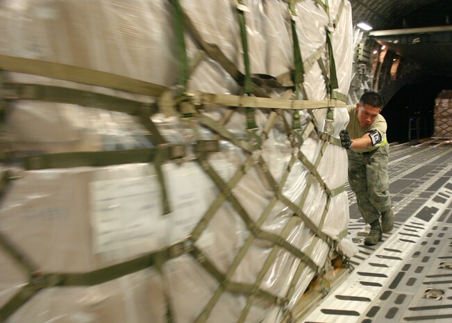 Air Cargo Specialist Senior Airman Rodrigo Maranon of the 437th Aerial Port Squadron pushes a palette of personal protective kits into position aboard a U.S. Air Force C-17 Globemaster III, May 8. The kits are part of a U.S. Agency for International Development shipment to Haiti, Guatemala, Honduras, El Salvador, Nicaragua and Belize to help these nations prepare for a potential outbreak of the H1N1 influenza virus. (Photo by Raymond Sarracino, U.S. Southern Command Public Affairs)

