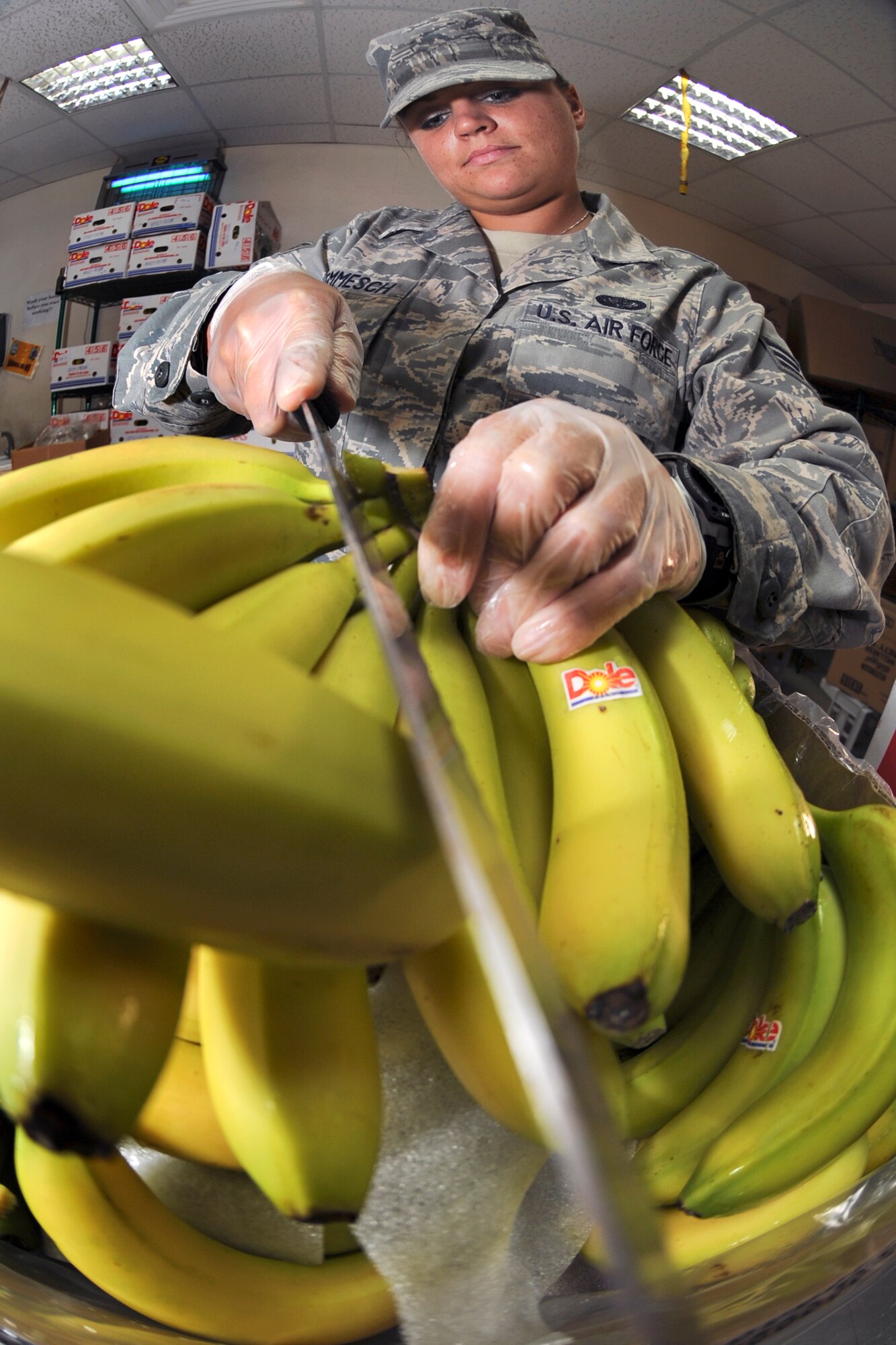 Senior Airman Kayla Hemmesch, a food service journeyman with the 379th Expeditionary Force Support Squadron, cuts loose individual bananas for the 'Grab n Go' food line, May 12, 2009, in an undisclosed location in Southwest Asia.  Airman Hemmesch and fellow co-workers aid contract workers in the preparation and serving of food for base personnel.  Airman Hemmesch is native to Spring Hill, Minn. and is deployed from Elmendorf Air Force Base, Alaska in support of Operations Iraqi and Enduring Freedom and Combined Joint Task Force - Horn of Africa.  (U.S. Air Force Photo by Staff Sgt. Joshua Garcia/released)