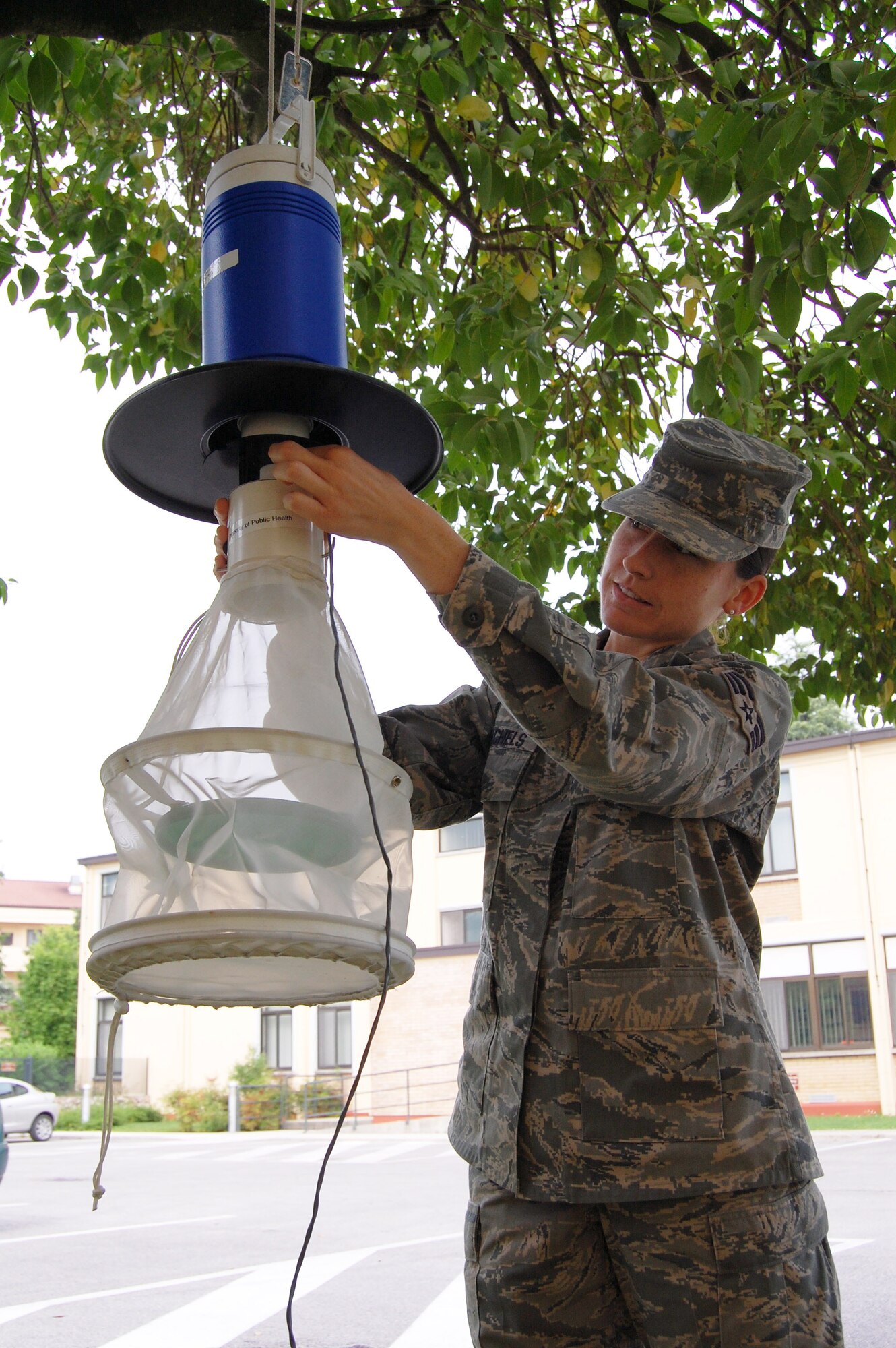 Senior Airman Tessie Rachels, 31st Aerospace Medicine Squadron public health technician, sets up a mosquito trap in Area 1. The public health flight will be using several traps throughout Areas F and 1 to assist them in surveying and combating the mosquito population on base this summer. People are asked not to tamper with the traps. (U.S. Air Force photo/Staff Sgt. Lindsey Maurice)