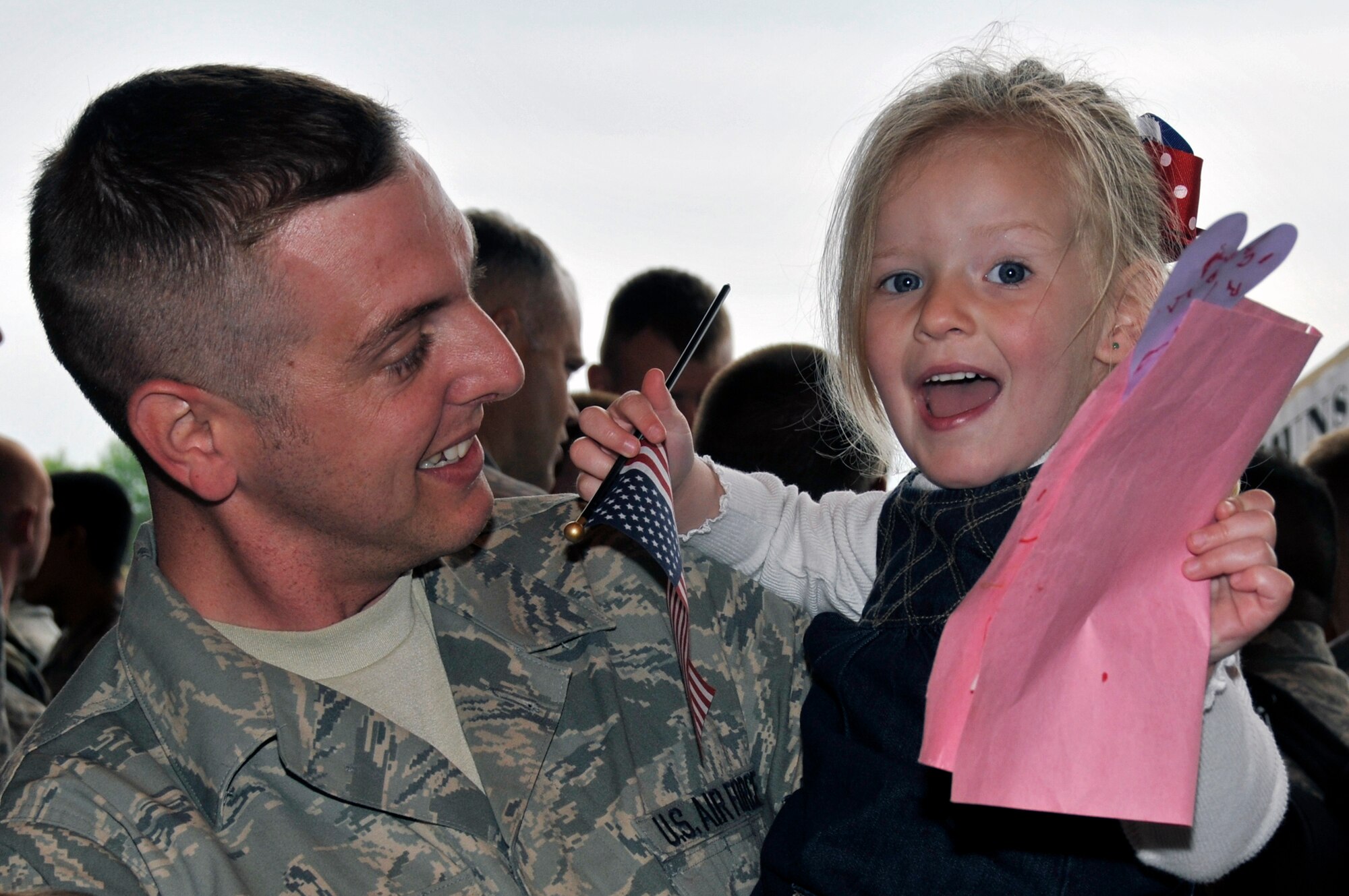 ROYAL AIR FORCE LAKENHEATH, England -- Emma Bauer smiles with excitement, held in arms of her father Master Sgt. Scott Bauer, 48th Aircraft Maintenance Squadron section chief, just returned home from Afghanistan May 13, 2009. Over 250 Airmen returned from a four month deployment to Afghanistan in support of Operation Enduring Freedom. (U.S. Air Force photo by Airman 1st Class Perry Aston) 