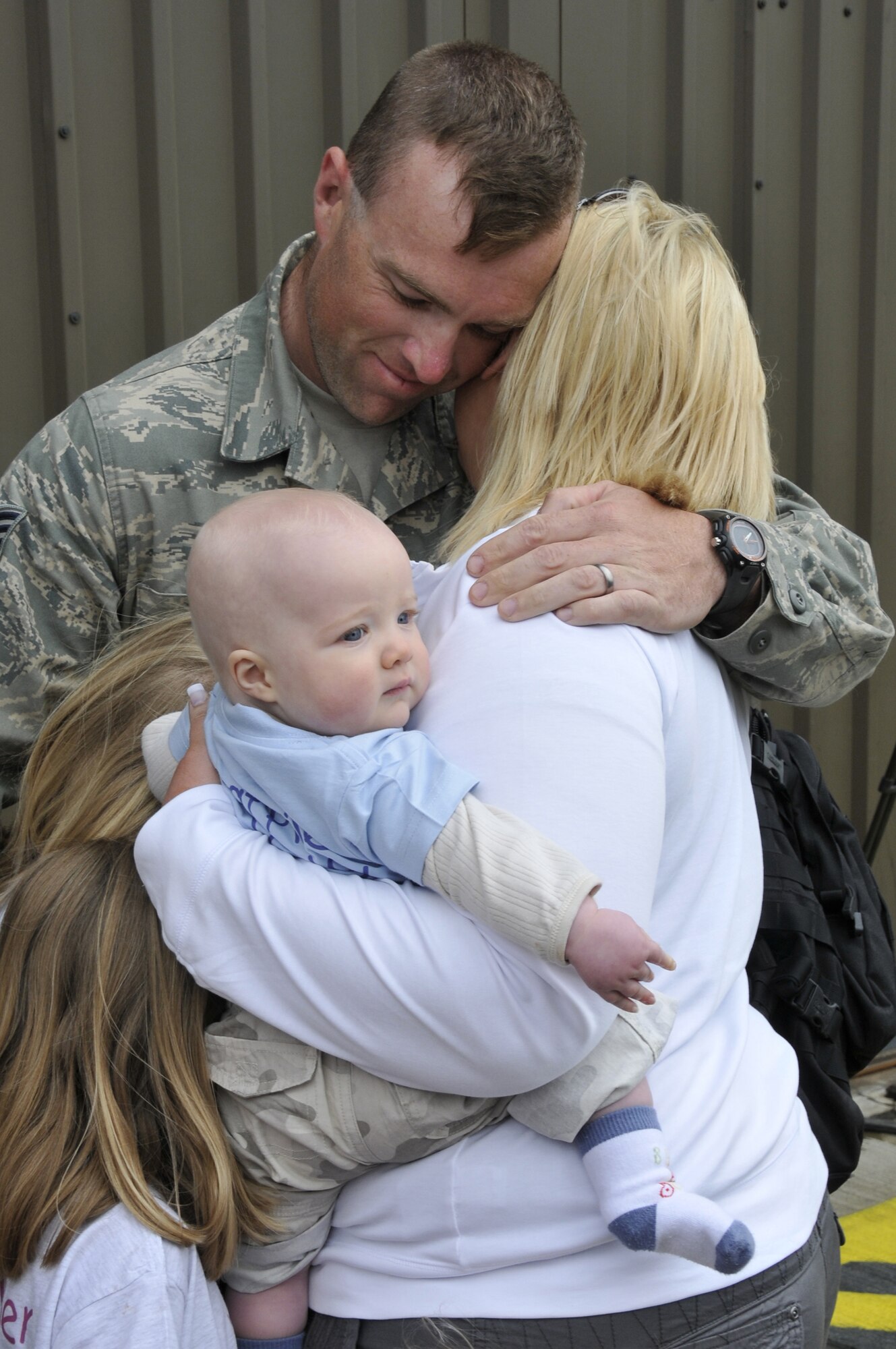 ROYAL AIR FORCE LAKENHEATH, England -- Tech Sgt. Kerry Pliler, 48th Aircraft Maintenance Squadron flight line expeditor, hugs his wife and kids for the first time in four months May 13, 2009. Over 250 Airmen, primarily from the 492nd Fighter Squadron, returned from a four month deployment to Afghanistan in support of Operation Enduring Freedom. (U.S. Air Force photo by Airman 1st Class Perry Aston) 