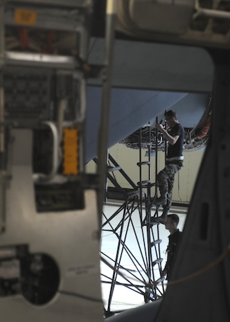 A team Charleston airman climbs a a ladder to work on a C-17 during the unit compliance inspection here May 12. The inspection is to ensure that Charleston members are ready and able to react to a real world crisis at home station. (U.S. Air Force photo/Senior Airman Katie Gieratz)