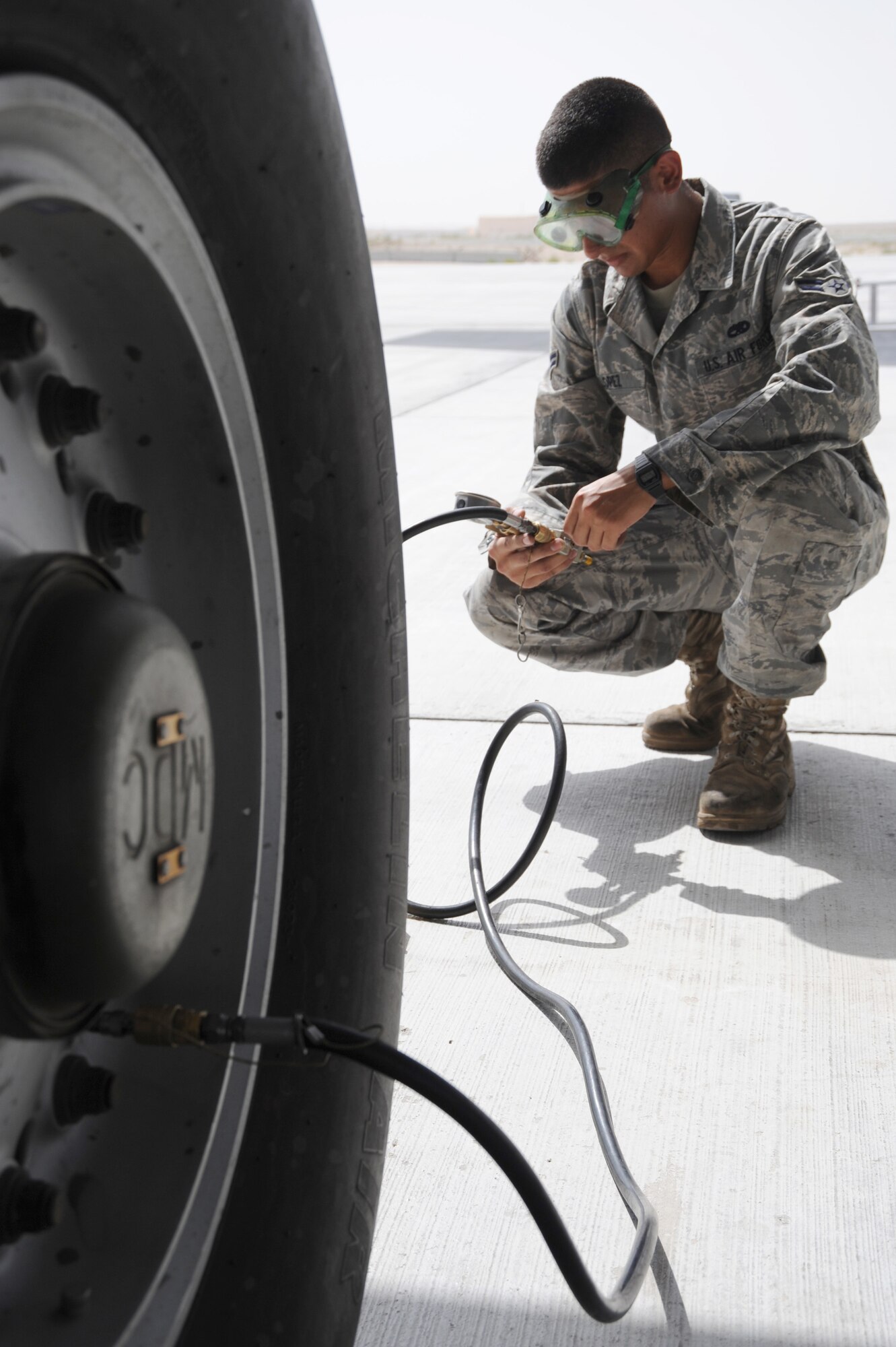 Airman 1st Class Daniel Lopez, 380th Expeditionary Aircraft Maintenance Squadron, checks the tire pressure on a KC-10 Extender, May 13 at an undisclosed location in Southwest Asia. Tire pressure is checked during pre-launch to ensure that it meets requirements for take-off and landing. (U.S. Air Force photo by Senior Airman Brian J. Ellis) (Released)