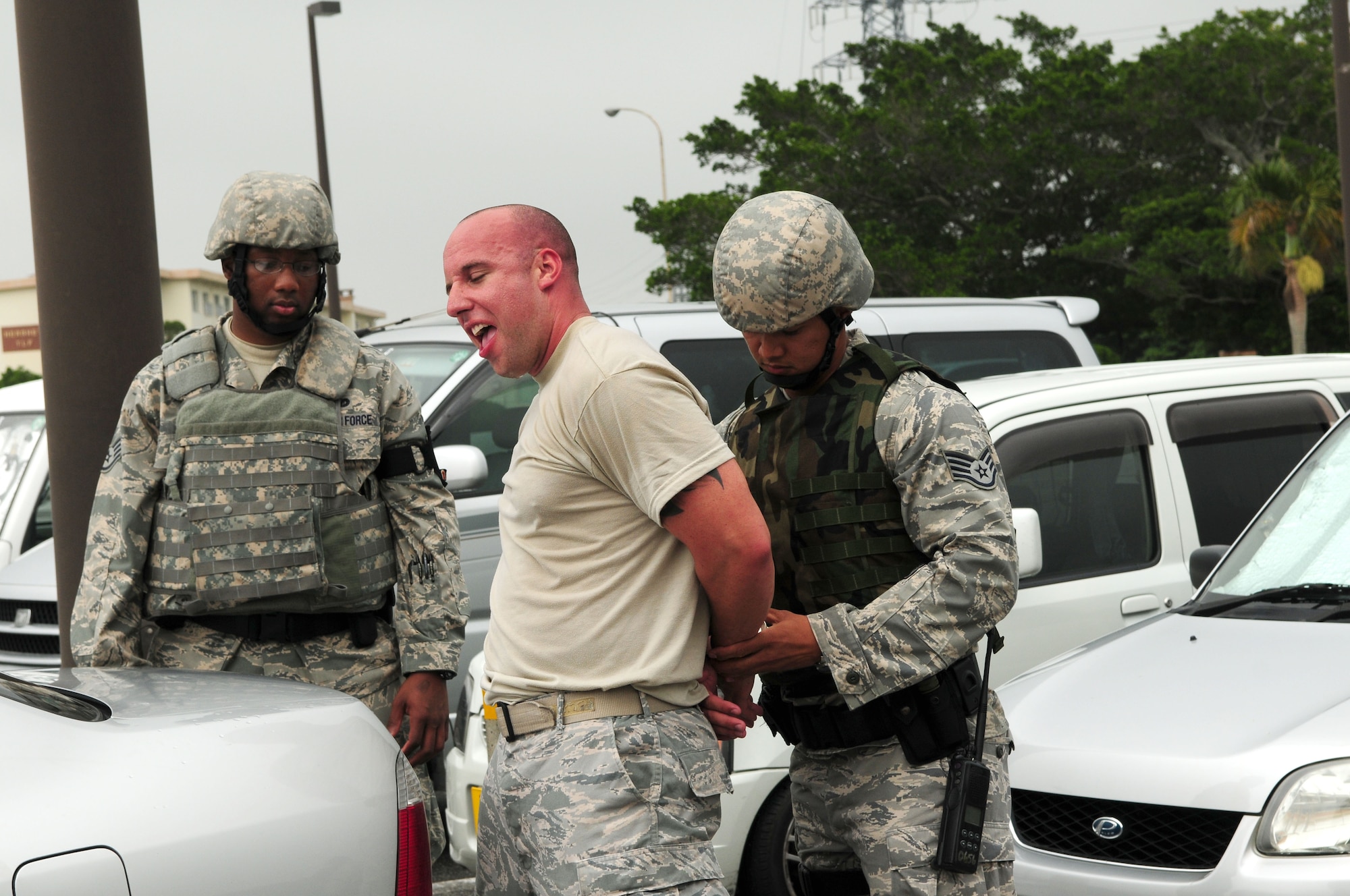 A simulated bank robber is apprehended by Staff Sgt. Joshua Tyquiengco, right and Staff Sgt. Justin Rose, both from the 18th Security Forces Squadron, during Beverly High 09-2 Local Operational Readiness Exercise May 12. The LORE tests base personnel on their readiness for real world emergency/combat events. (U.S. Air Force photo/Staff Sgt. Lakisha A. Croley)