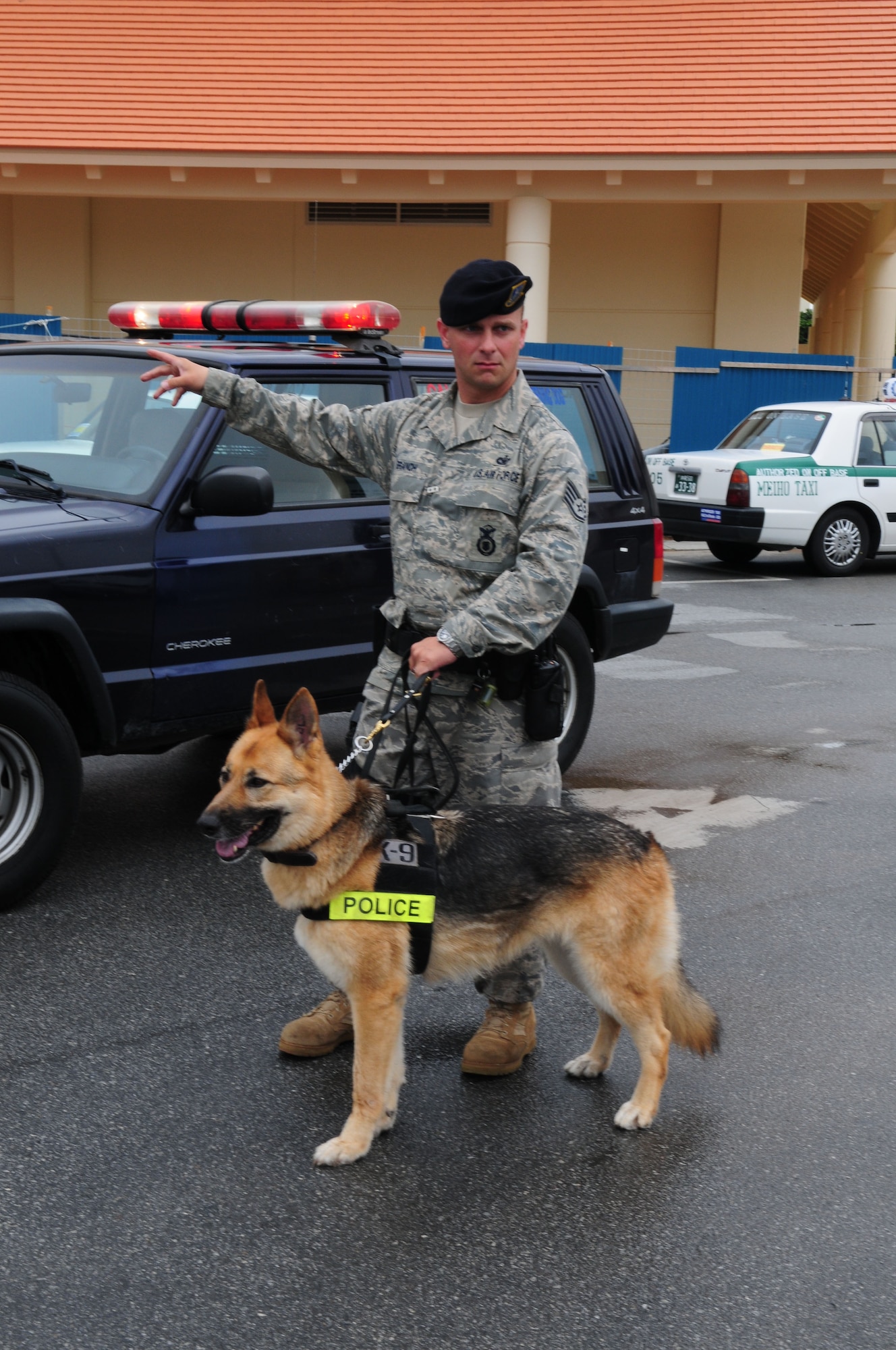Zena, an 18th Security Forces military working dog, stands by her handler, Staff Sgt. Joshua Branch, before approaching a suspected bank robber during Beverly High 09-2 Local Operational Readiness Exercise May 12. The LORE tests base personnel on their readiness for real world emergency/ combat events. (U.S. Air Force photo/ Staff Sgt. Lakisha A. Croley)