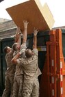 Marines with 2nd battalion, 24th Marines and 1st Marine Division throw recyclables into the first of two dumpsters during a clean-up of the Cornerstone Community Center's basement May 13. The Marines were on hand  as a volunteer effort during the first ever Marine Week.