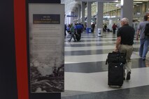 Travelers walk by historical and informative documentations at Chicago O'Hare International Airport that are posted as part of a traveling display from the National Museum of the Marine Corps May 13, 2009. The exhibit was placed in the airport's high traffic areas as part of an informative and interactive part of Marine Week Chicago. (U.S. Marine Corps photo by Cpl. Seth Maggard/Released)