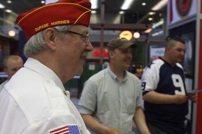 Patrons and retired Marines share stories and information on Marine Corps traditions at a traveling display at Chicago O'Hare International Airport May 13, 2009. The exhibit was placed in the airport's high traffic areas as part of an informative and interactive part of Marine Week Chicago. (U.S. Marine Corps photo by Cpl. Seth Maggard/Released)