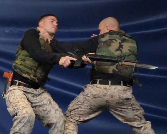 Staff Sgt. Michael Jones, instructor trainer, Martial Arts Center of Excellence, Quantico, Va., uses Sgt. Steven Richardson, instructor trainer, MACE, Quantico, Va., to demonstrate how to disarm an advancing enemy during a demonstration at Soldier Field May 13.