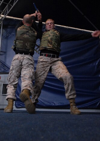 Sgt. Joshua Ott, instructor trainer, Martial Arts Center of Excellence, Quantico Va., demonstrates how to disarm an enemy trying to strike over-head using Sgt. Timothy Ainsworth, physical training instructor, Officer Candidate School, Quantico, Va. at Soldier Field May 13.