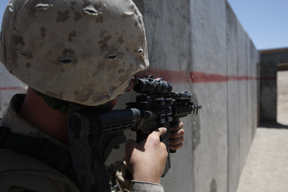 Pfc. Rick O’Donnell, a light armored vehicle crewman with Company E, 3rd Light Armored Reconnaissance Battalion, protects an open hallway for the other Marines in his fire team during the company’s assault on Combat Center Range 111, May 14.