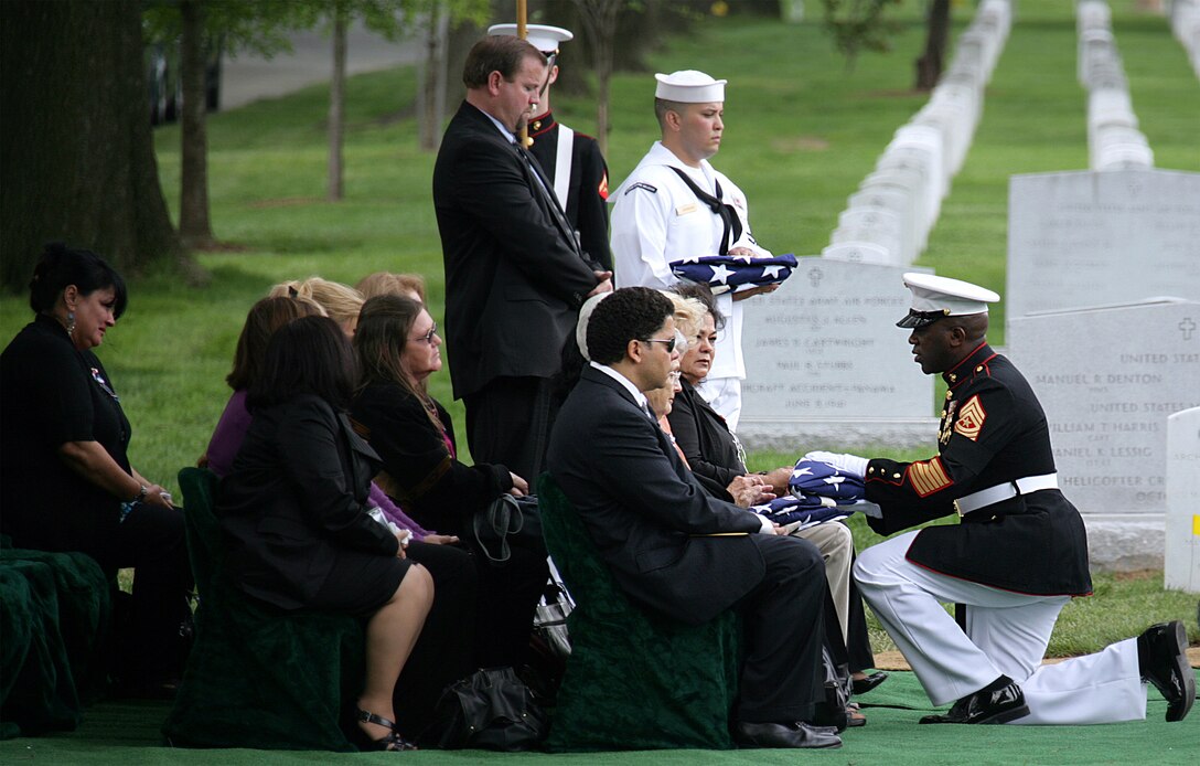 Sgt Maj. Ronald Green presents burial flags to family members of six Vietnam War casualties during a repatriation service May 14. After 41 years, the remains of six Marines killed in Vietnam were identified, repatriated and interred in a group burial.