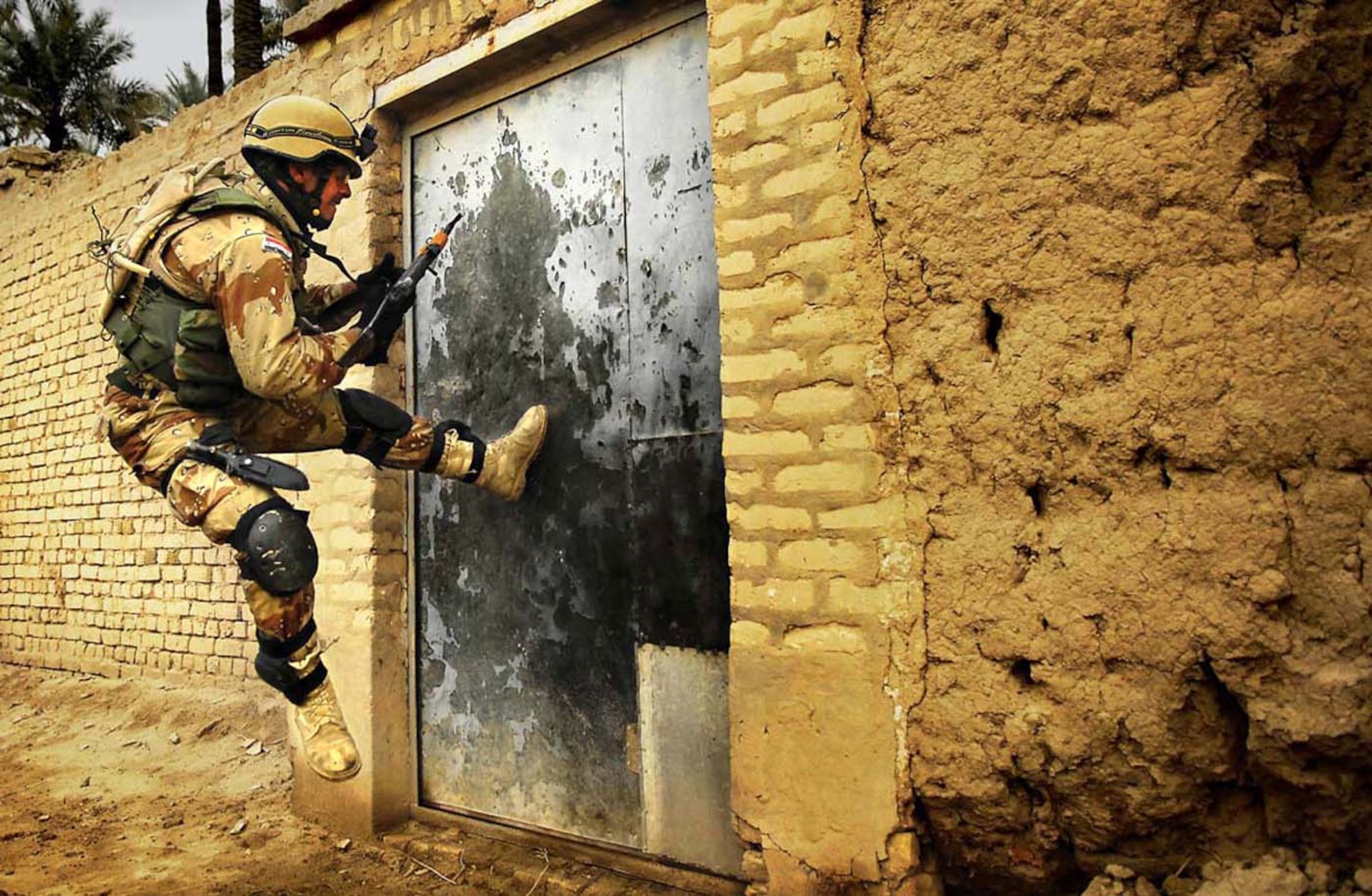 The Stacy Pearsall Combat Photo Gallery — A Military Photographer of the Year, Pearsall‘s work has been viewed worldwide. An Iraqi army soldier tries to kick open a gate during a cordon and search for insurgence and weapons caches in Chubinait, Iraq, on Feb. 3, 2007. (photo by Staff Sgt. Stacy Pearsall)
