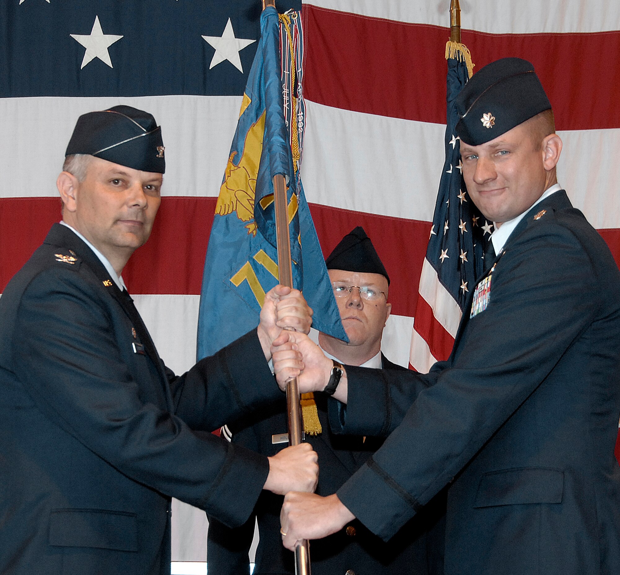 Lt. Col. David Merritt, right, accepts the command of the 71st Operations Support Squadron from Col. Glen VanHerck, the 71st Operations Group commander, during a change of command ceremony held May 8 in Hangar 170. Colonel Merritt, previously the 71st OSS director of operations, recently returned from a year-long deployment to Al Dhafra AB, United Arab Emirates. The former 71st OSS commander, Lt. Col. Vincent Losttetter Jr., will be attending the Israeli National Defense College in Tel Aviv, Isreal. (U.S. Air Force photo/Terry Wasson)