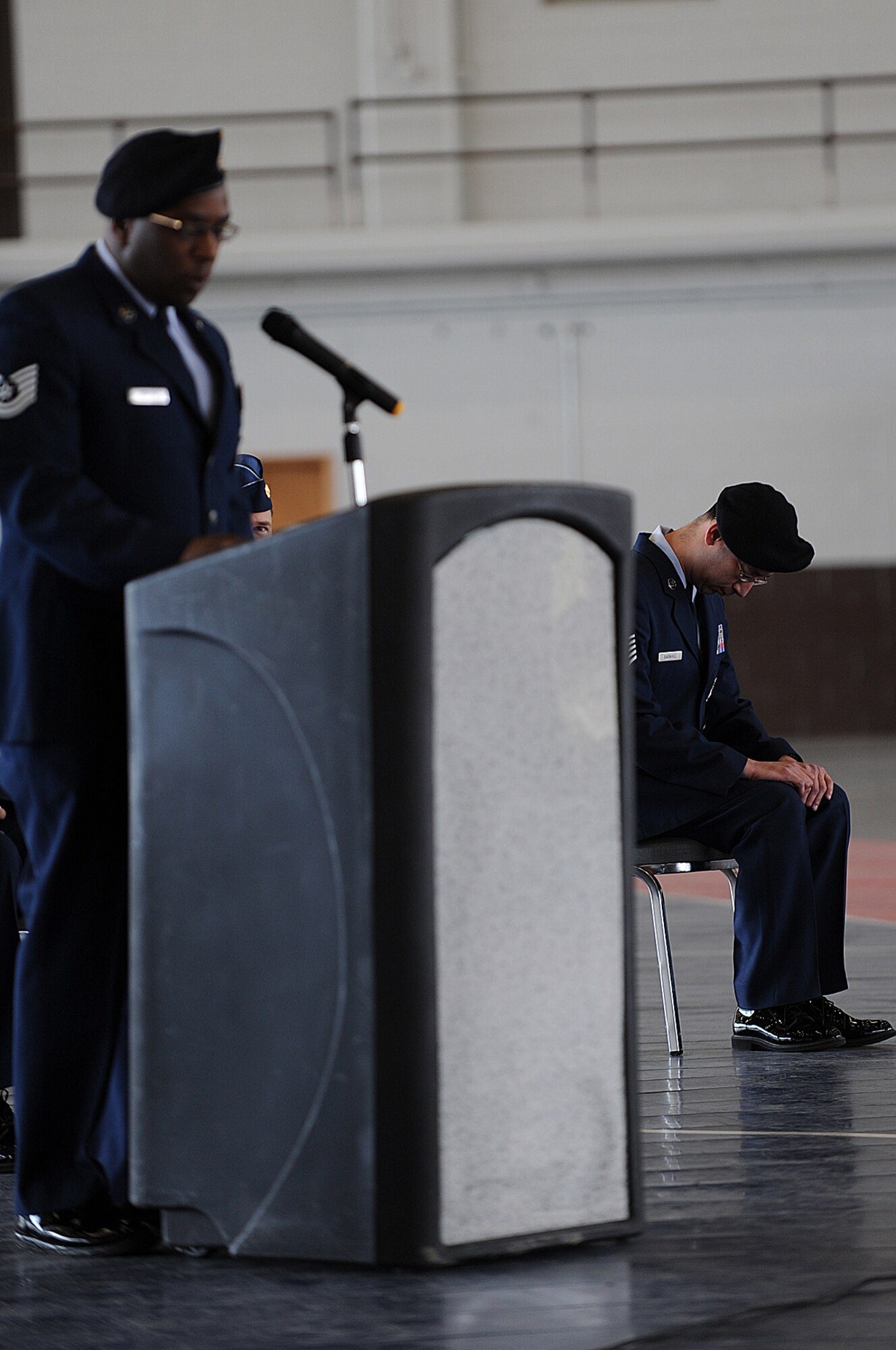 (Left) Tech Sgt. Drayton Denson, 28 Security Forces Squadron member, reads a roll call list of fallen police officers while Tech Sgt. Charles Barnhill, right, 28 SFS member, bows his head in honor and remembrance during a National Police Week retreat here, May 13. National Police Week honors all local, state, and federal law enforcement officers who serve and protect.  (U.S. Air Force photo/Airman 1st Class Joshua J. Seybert) 