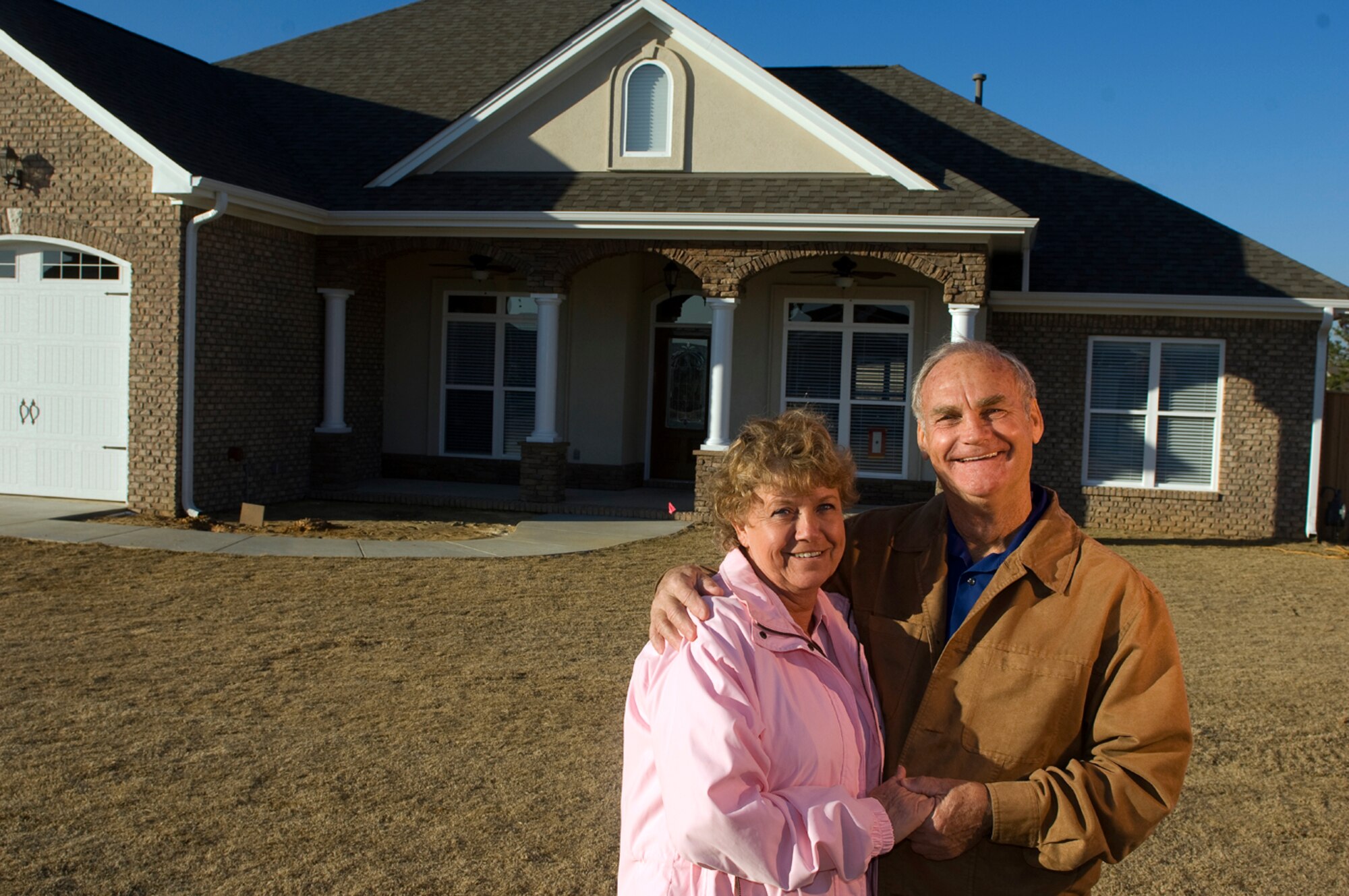 Twister survivors, retired Chief Master Sgt. and Ilah Glover were a somber couple in February 2008 (top photo) when a tornado destroyed their home in Prattville, Ala. A year later, their rebuilt 
home put smiles back on their faces. (photo by Tech. Sgt. Matthew Hannen)